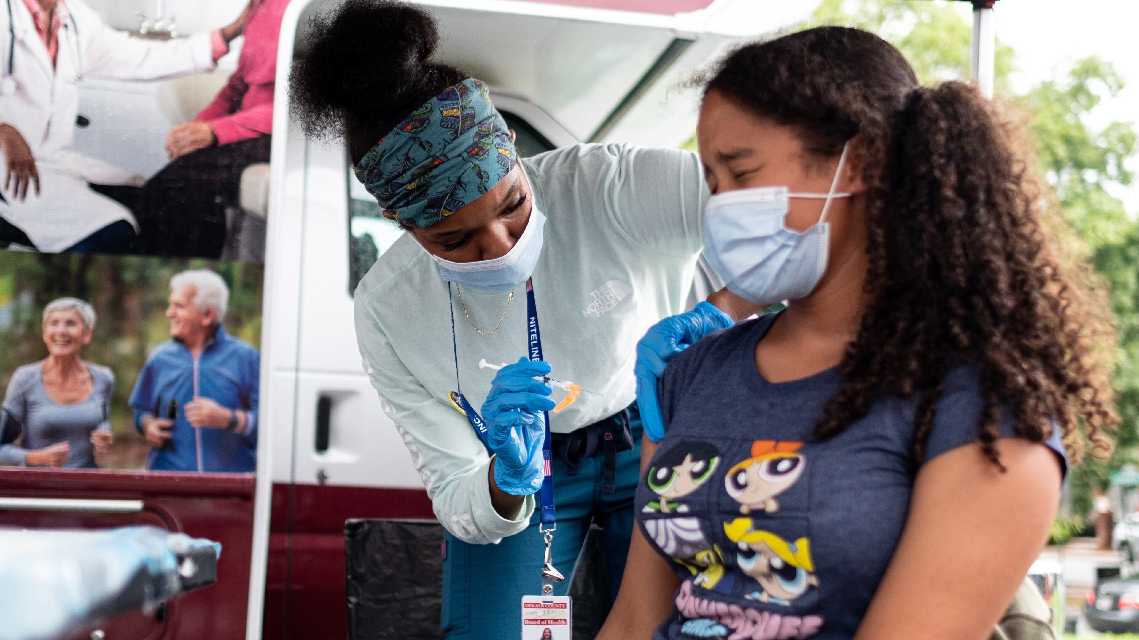 Ashanti Booker, a registered nurse with the DeKalb County Board of Health, gives a Covid-19 vaccination to Raya High, 13, at a mobile clinic at Decatur High School on July 19, 2021. The Pfizer-BioNTech vaccine may soon be authorized for emergency use with children as young as 5. Ben Gray for the Atlanta Journal-Constitution