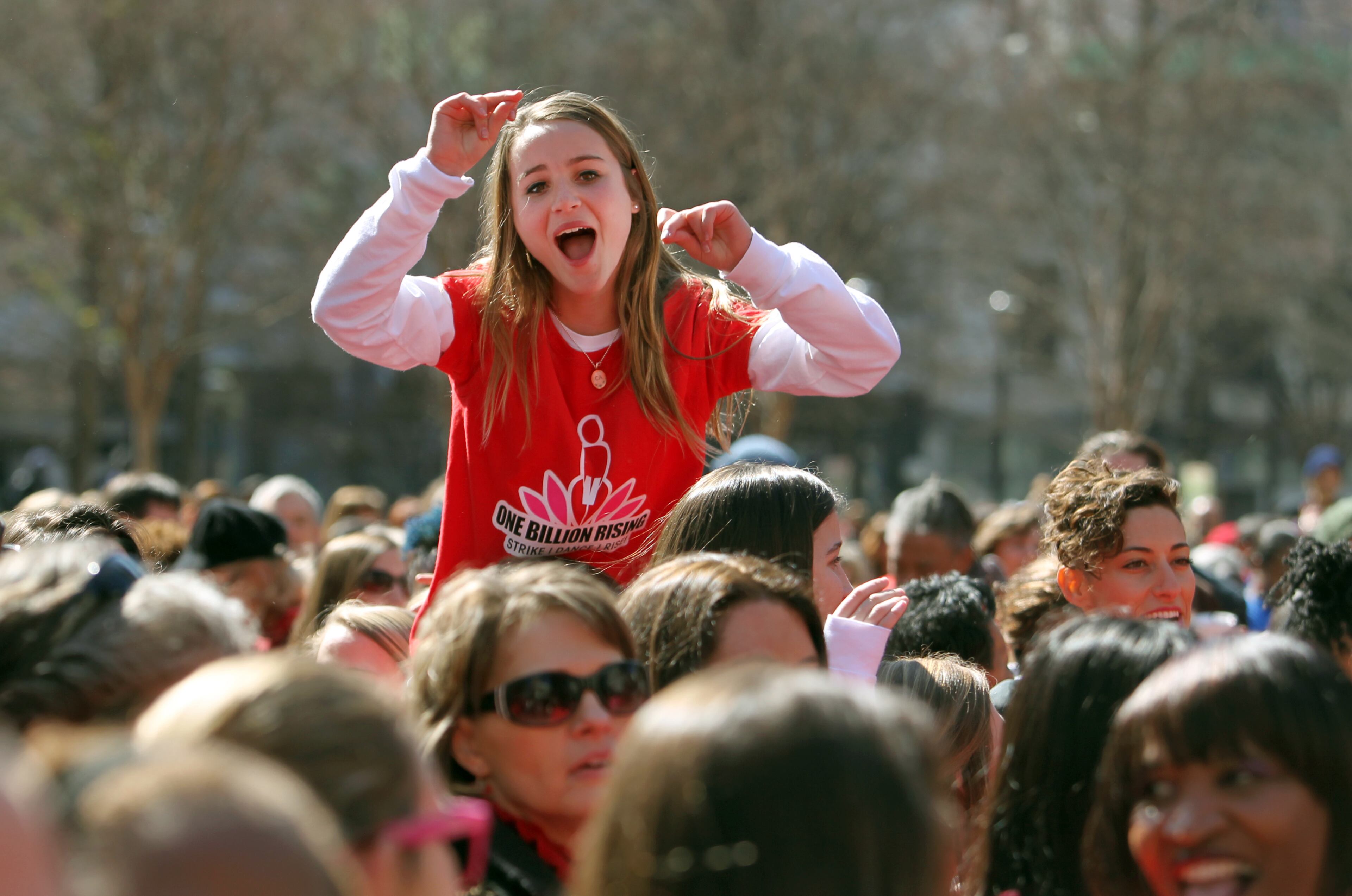 A girl sits on a friend's shoulders during the flash mob.