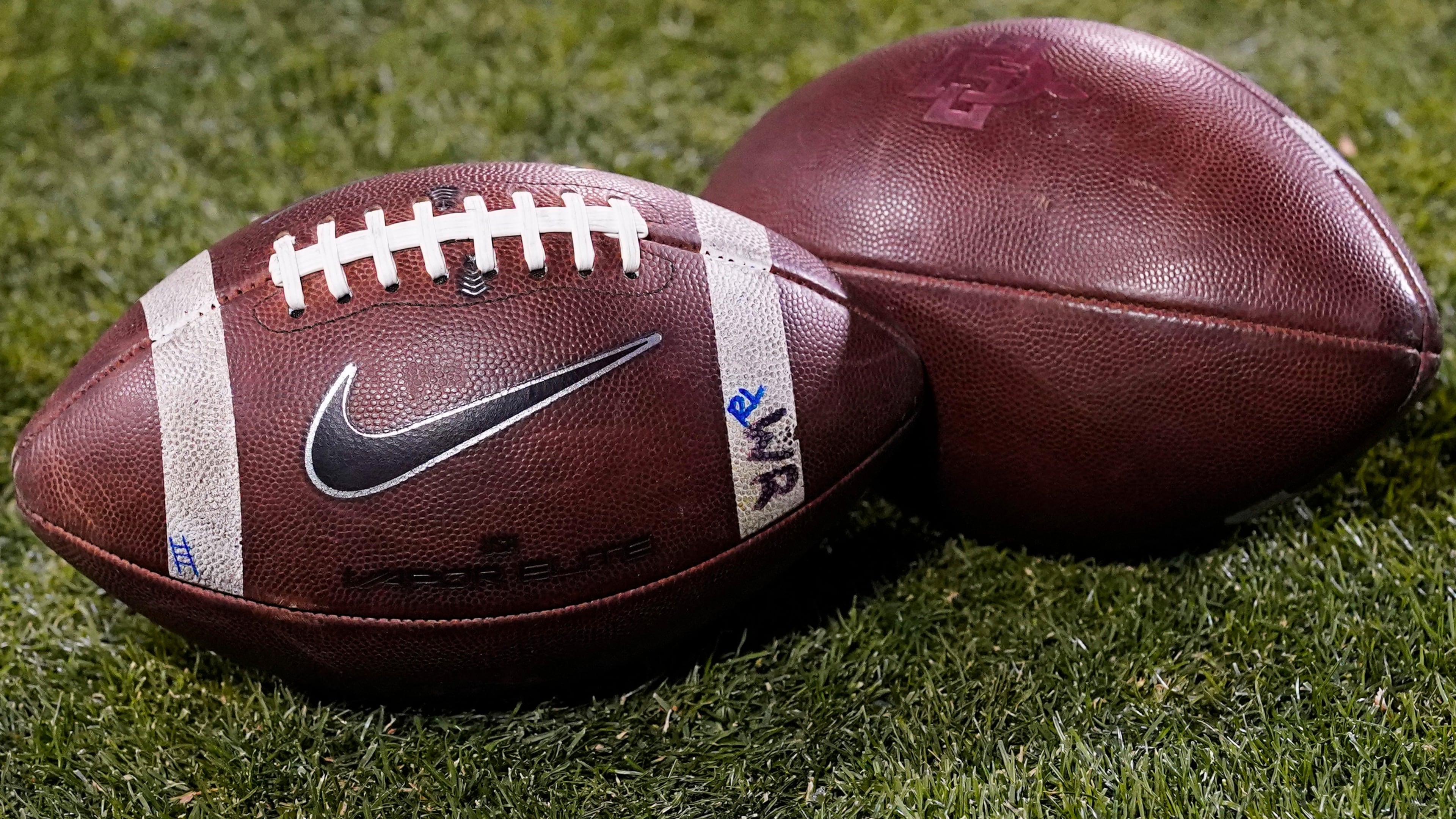 FILE - Footballs rest on the field in the second half of an NCAA college football game Nov. 28, 2020, in Boulder, Colo. (AP Photo/David Zalubowski, File)