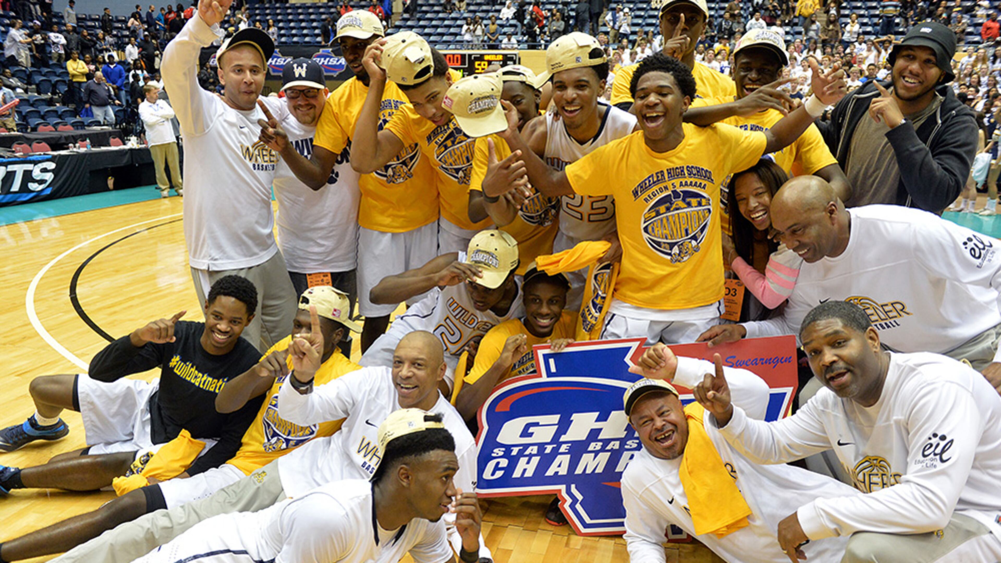 Wheeler Wildcats coaches and players celebrate their 2015 Class AAAAAA championship win. (Kent D. Johnson/AJC)