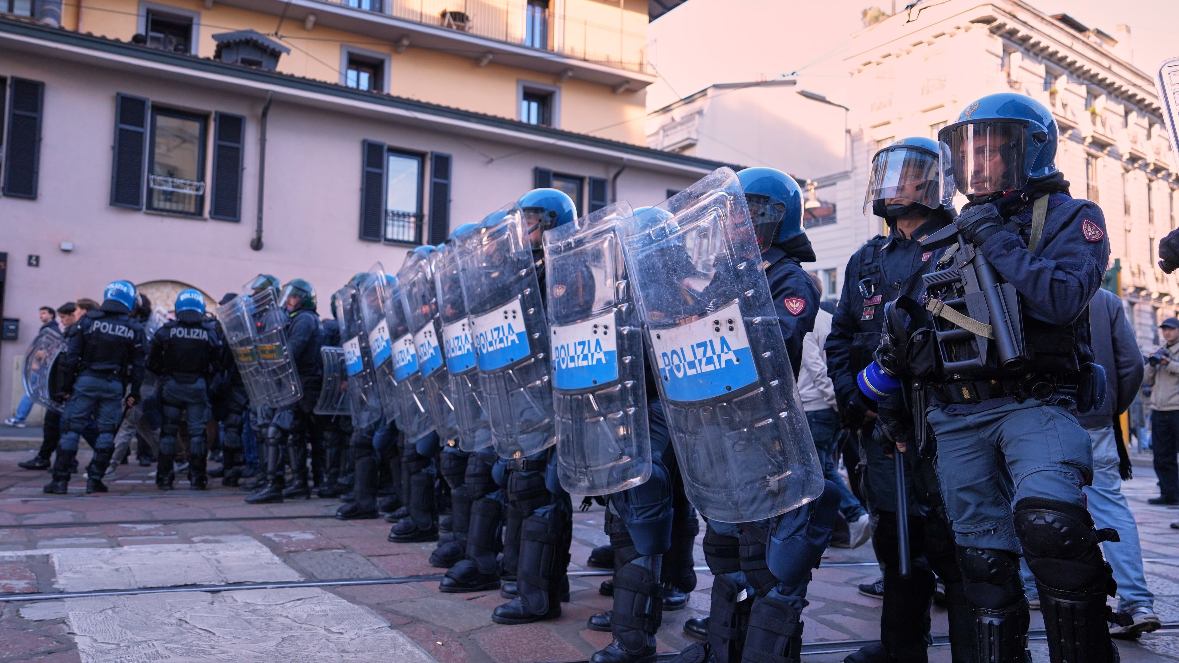 Anti-riot police watch as demonstrators march through the streets of Milan, Italy, Saturday, Oct. 24, 2026, to protest against the rising cost of living and deteriorating public services, during one of several demonstrations organized across Italy by groups spanning the political spectrum. (AP Photo/Antonio Calanni)