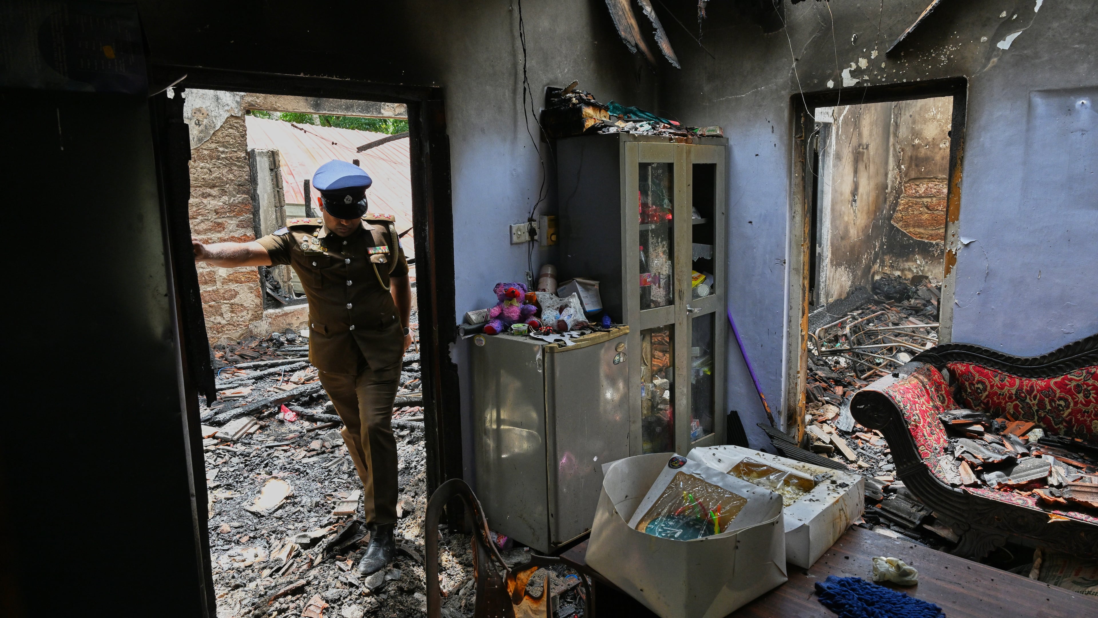 A Sri Lankan police officer inspects a charred elderly care home following an overnight fire in Anguruwatota, Sri Lanka, Thursday, June 4, 2026. (AP Photo)