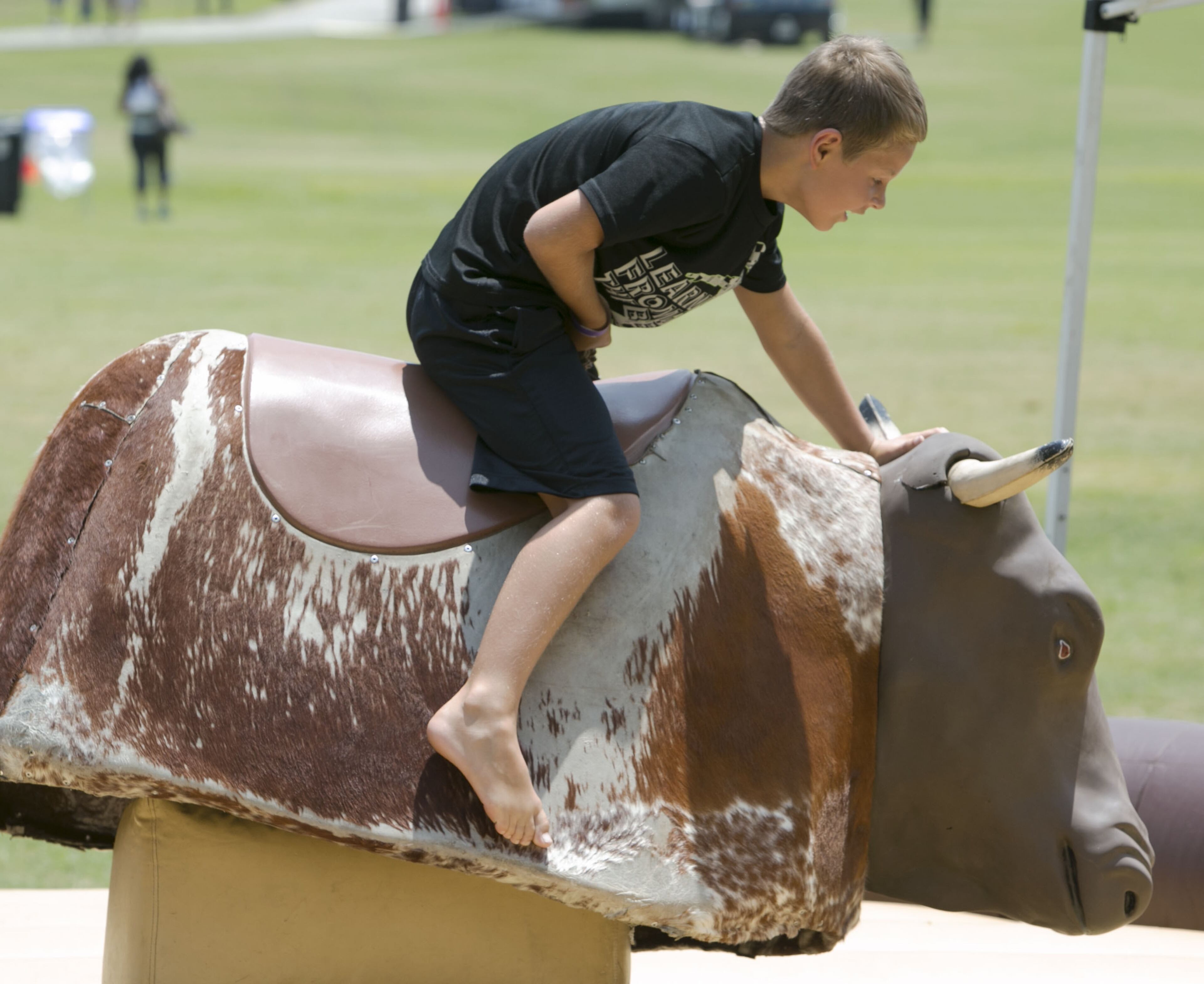 Eight-year-old Bailey Turner hung on to "Twister" the mechanical bull at the third annual Atlanta Street Food Festival at Piedmont Park in Atlanta on Saturday, July 12, 2014. (Photo by Phil Skinner)
