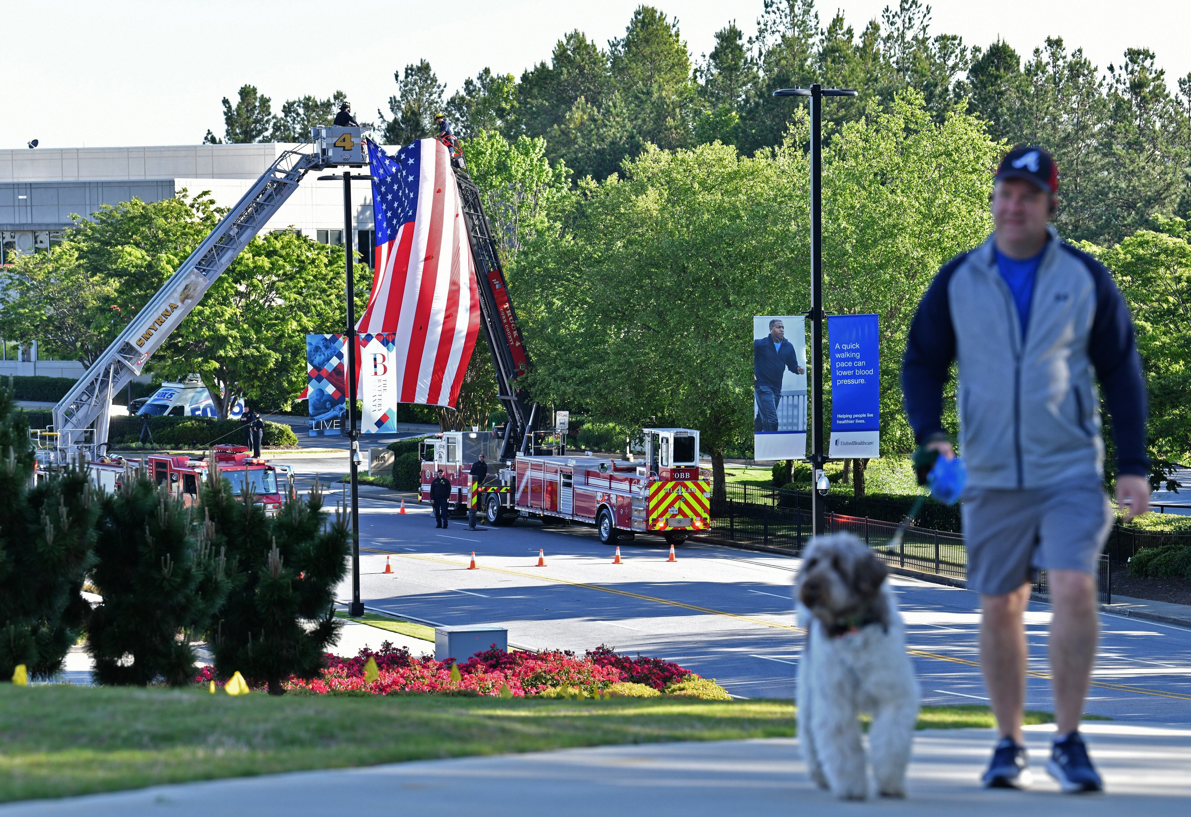 May 1, 2020 Smyrna - The Smyrna fire Department hangs an American flag on the way to the Truist Park before the start of the funeral service for Smyrna Officer Christopher Ewing on Friday, May 1, 2020. Numerous police vehicles participated in escorting the officer to Truist Park for the funeral service. Ewing, 34, died April 21 when his patrol car was struck by a suspected drunk driver. He was the third Georgia officer killed in the line of duty this. (Hyosub Shin / Hyosub.Shin@ajc.com)