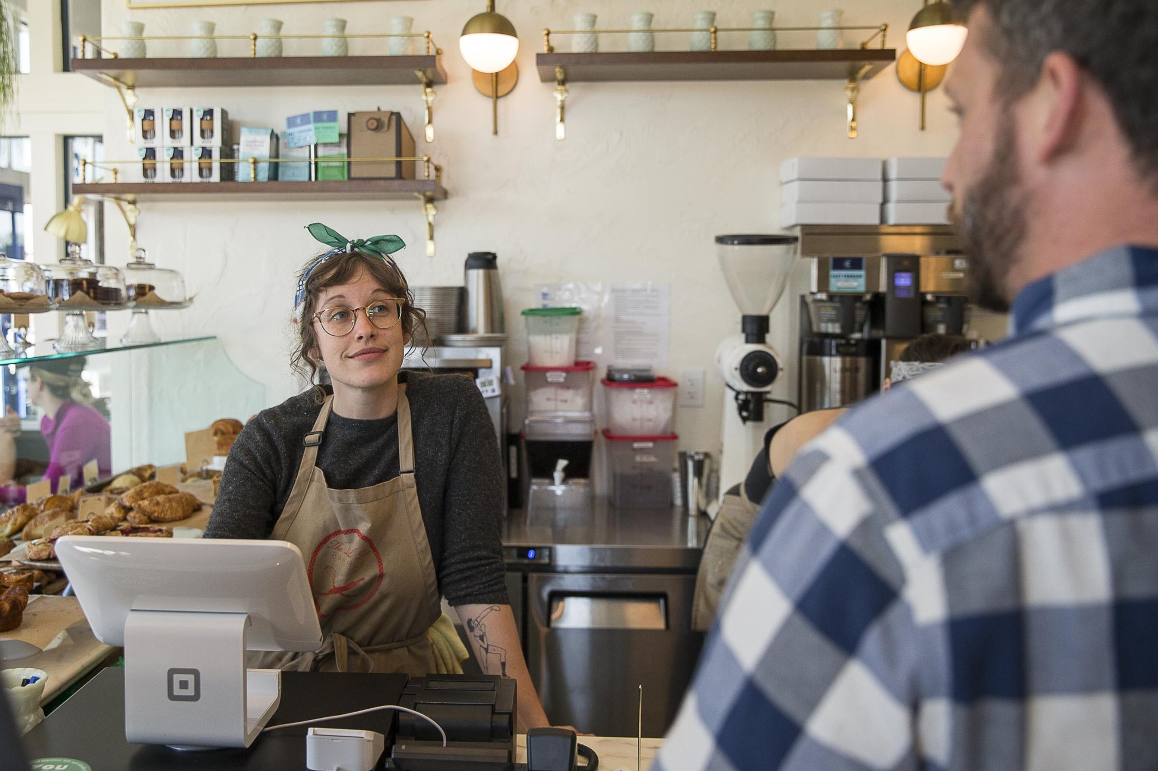 Little Tart Bakeshop employee Amy Gregg, left, works with a customer at the bakery in the Summerhill community.