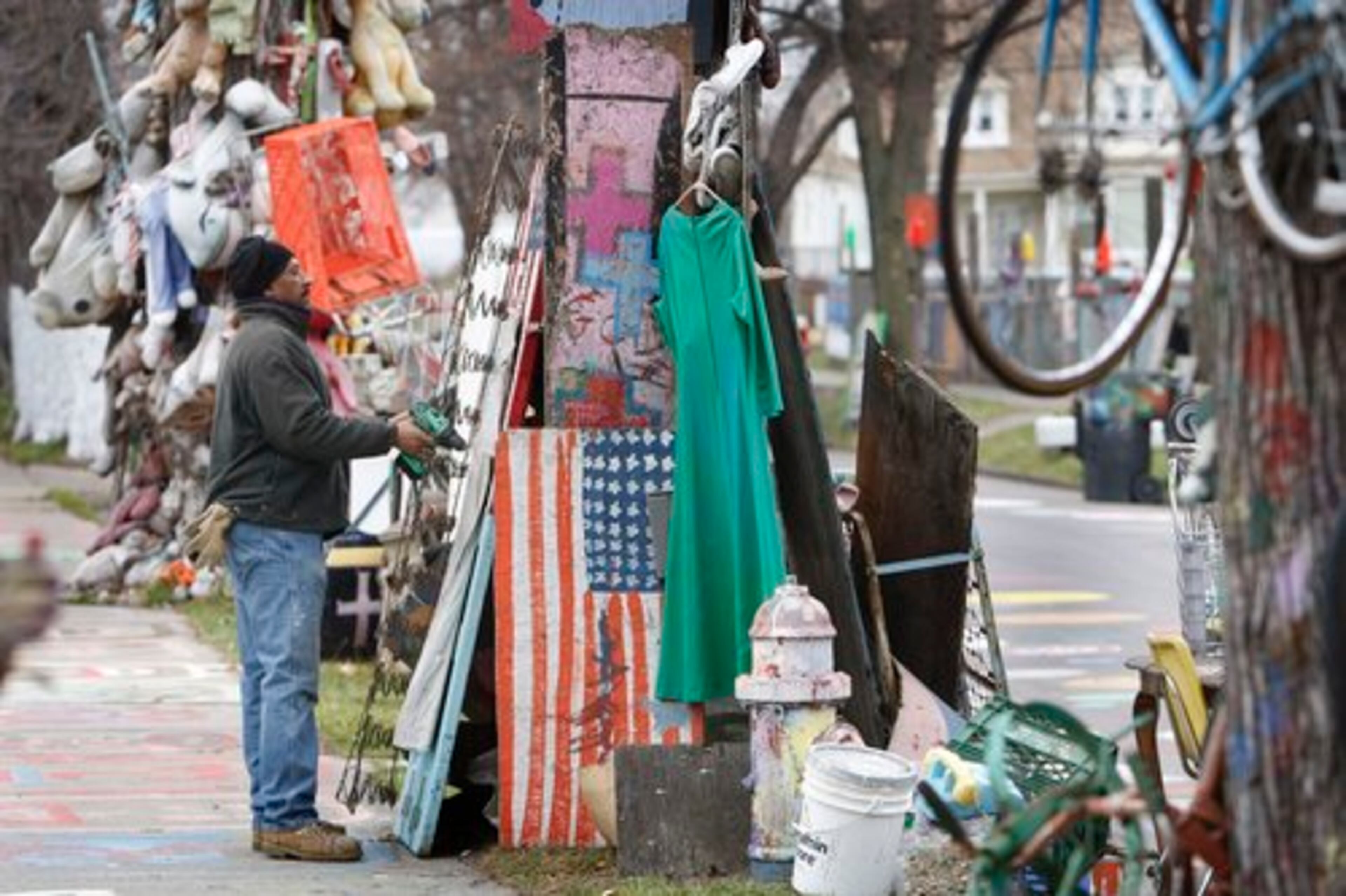 The work harks back to two decades ago when Tyree Guyton transformed a deteriorating Detroit neighborhood into a colorful, outdoor art gallery. Here, Guyton is seen at his Heidelberg Project in Detroit.