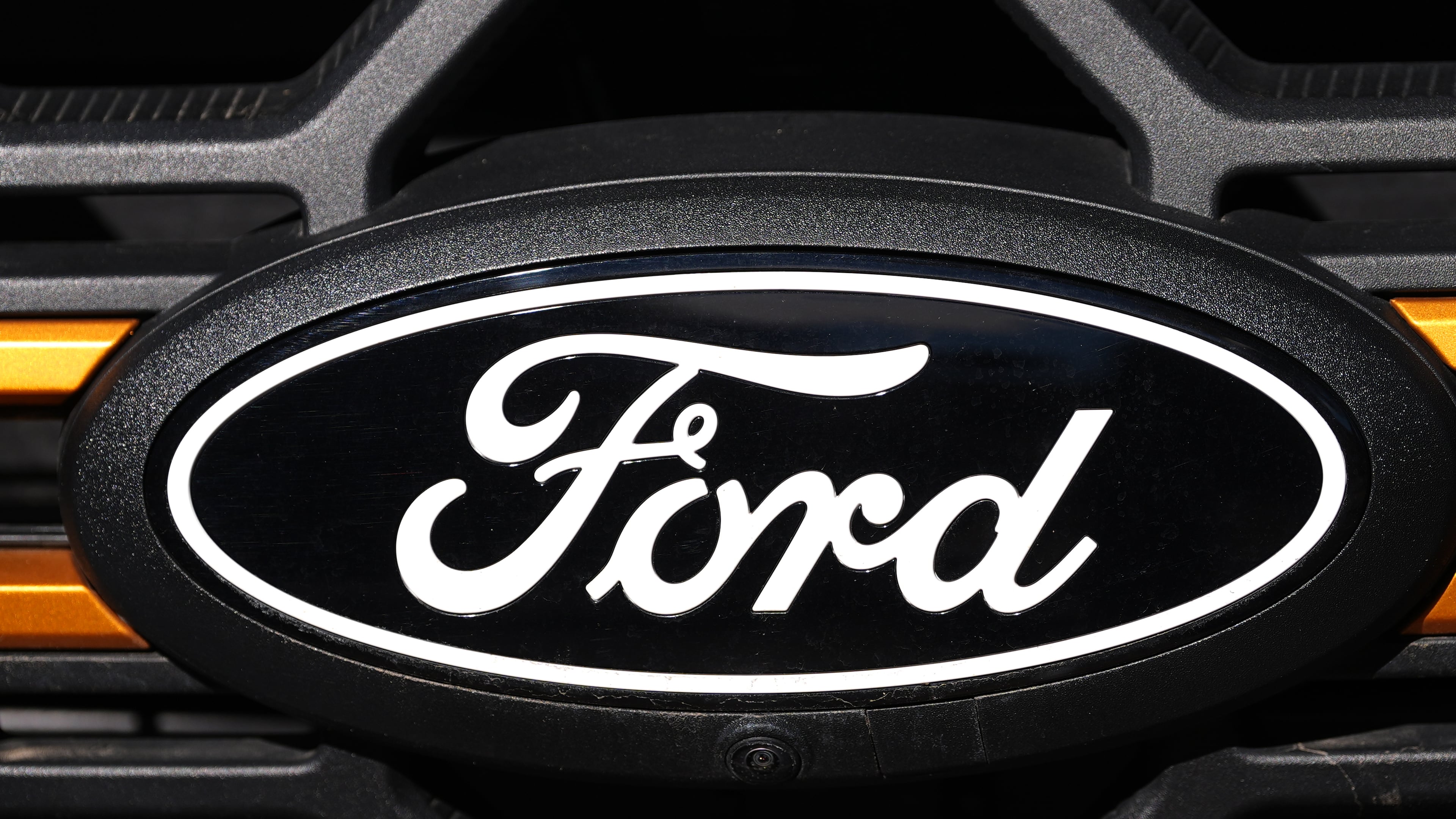 FILE - A Ford logo is seen on the grille of an unsold vehicle at a Ford dealership, Nov. 2, 2025, in Littleton, Colo. (AP Photo/David Zalubowski, File)