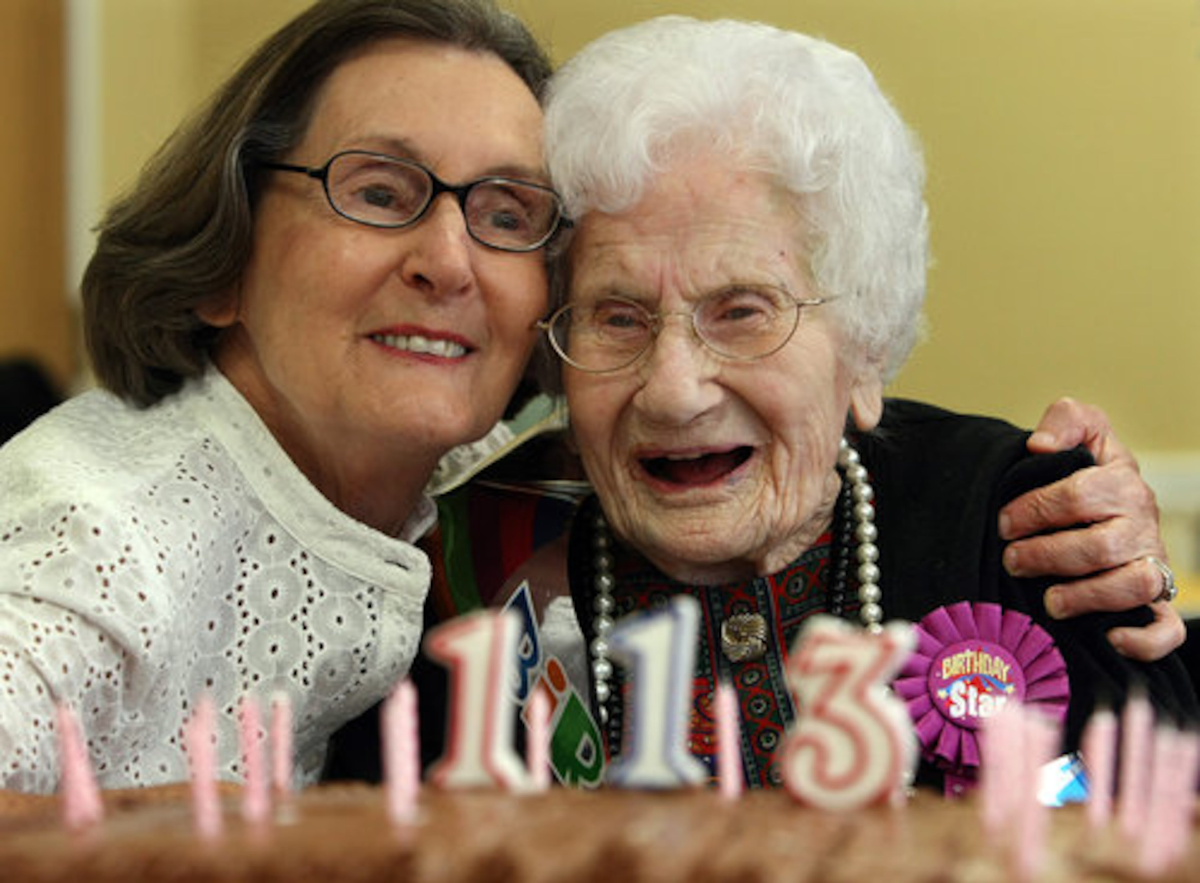 Besse Cooper gets a hug from her daughter-in-law Edith Cooper after blowing out the candles on her birthday cake.