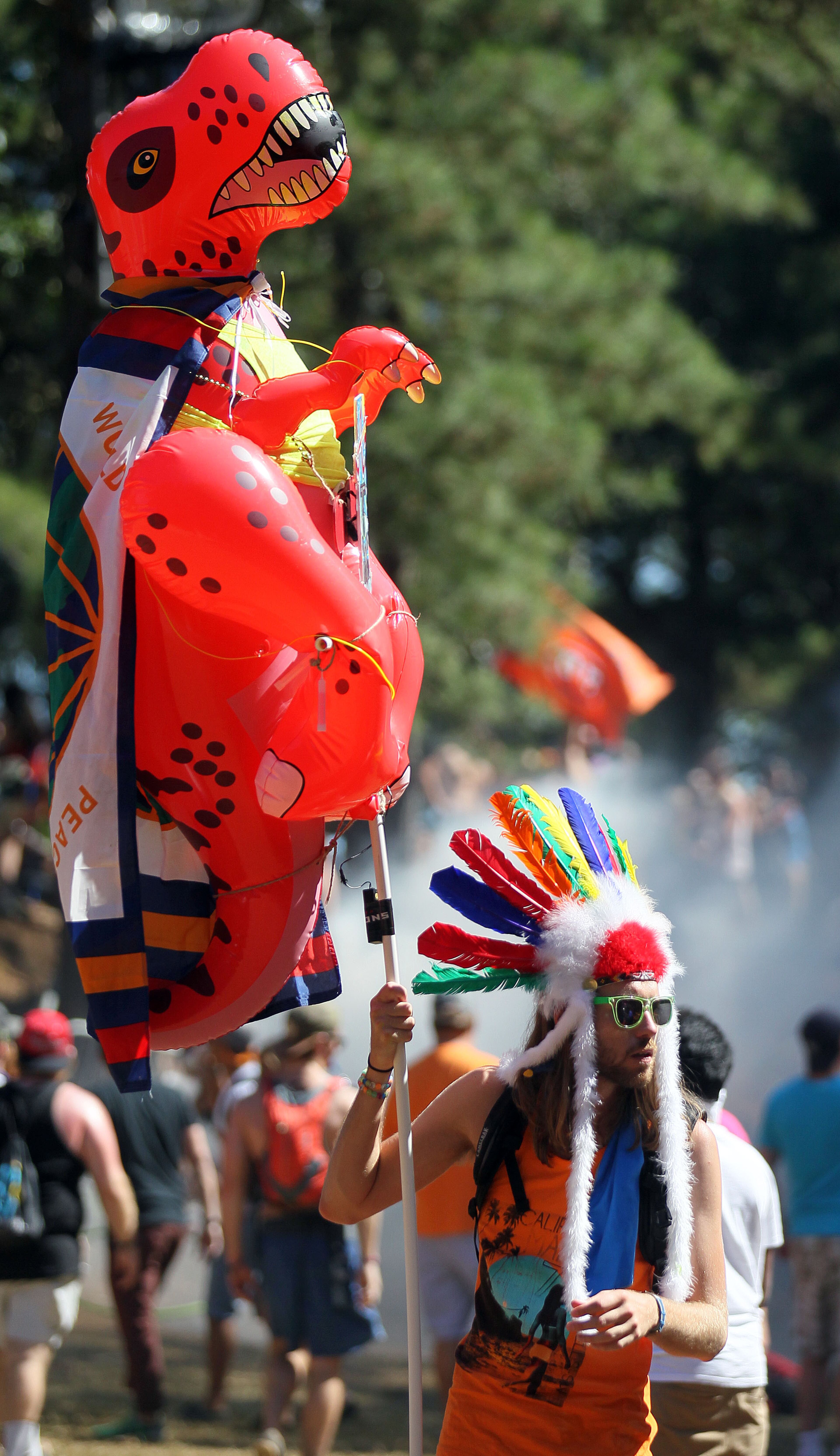 Dustin Clark, of Atlanta, carries an inflated dinosaur as he walks around the TomorrowWorld electronic music festival in Chattahoochee Hills, South of Atlanta, on Saturday September 28th, 2013. The event has been the world's most popular electronic music festival in Europe for years. It is in the United States for the first time on the nearly 500 acre Bouchaert Farm.