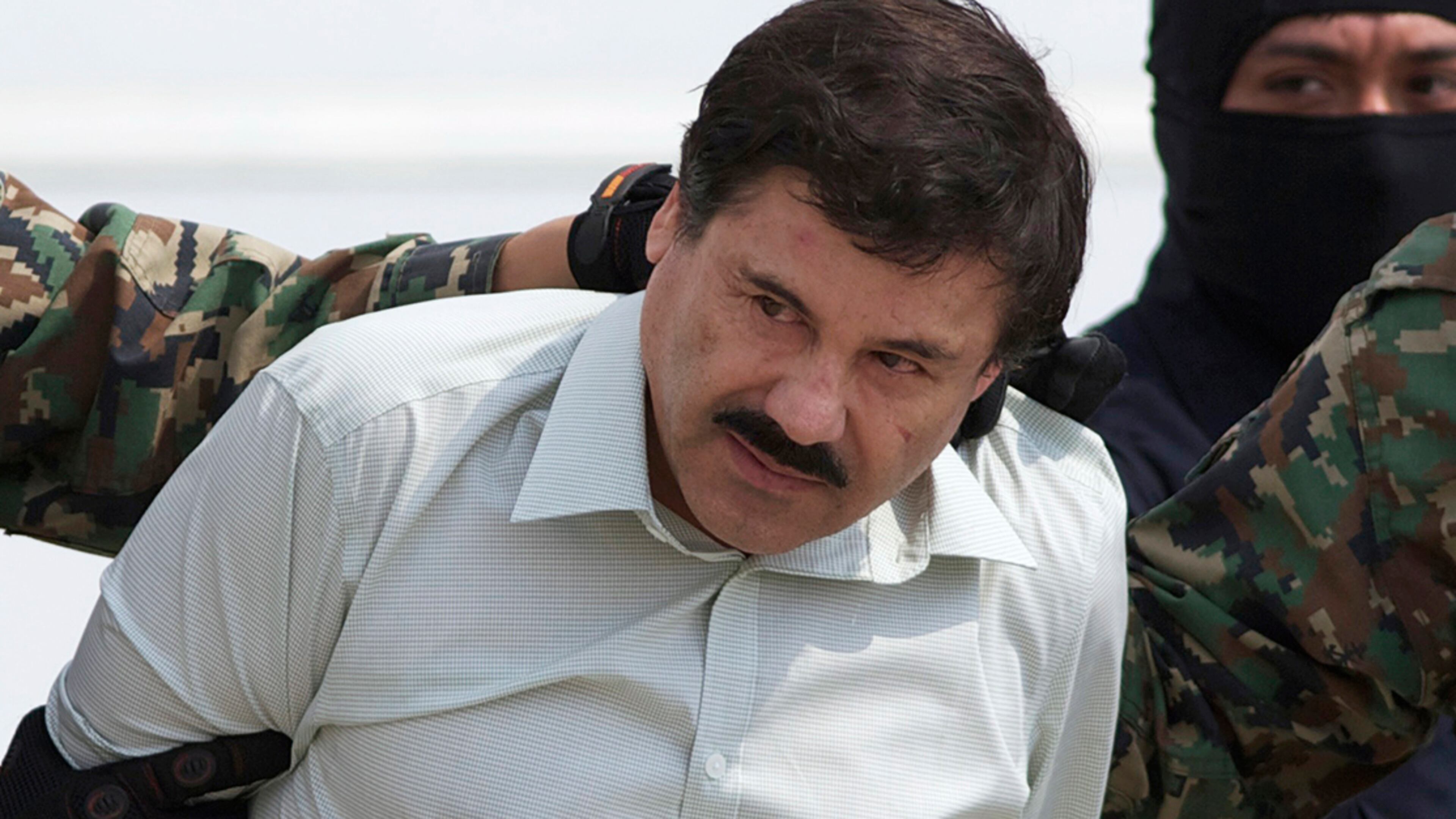 In this Feb. 22, 2014, file photo, Joaquin "El Chapo" Guzman, head of Mexico’s Sinaloa Cartel, is escorted to a helicopter in Mexico City, following his capture overnight in the beach resort town of Mazatlan. Mexico’s security commission said in a statement July 11, 2015, that Guzman has escaped from a maximum security prison, the second time he has fled after being captured.