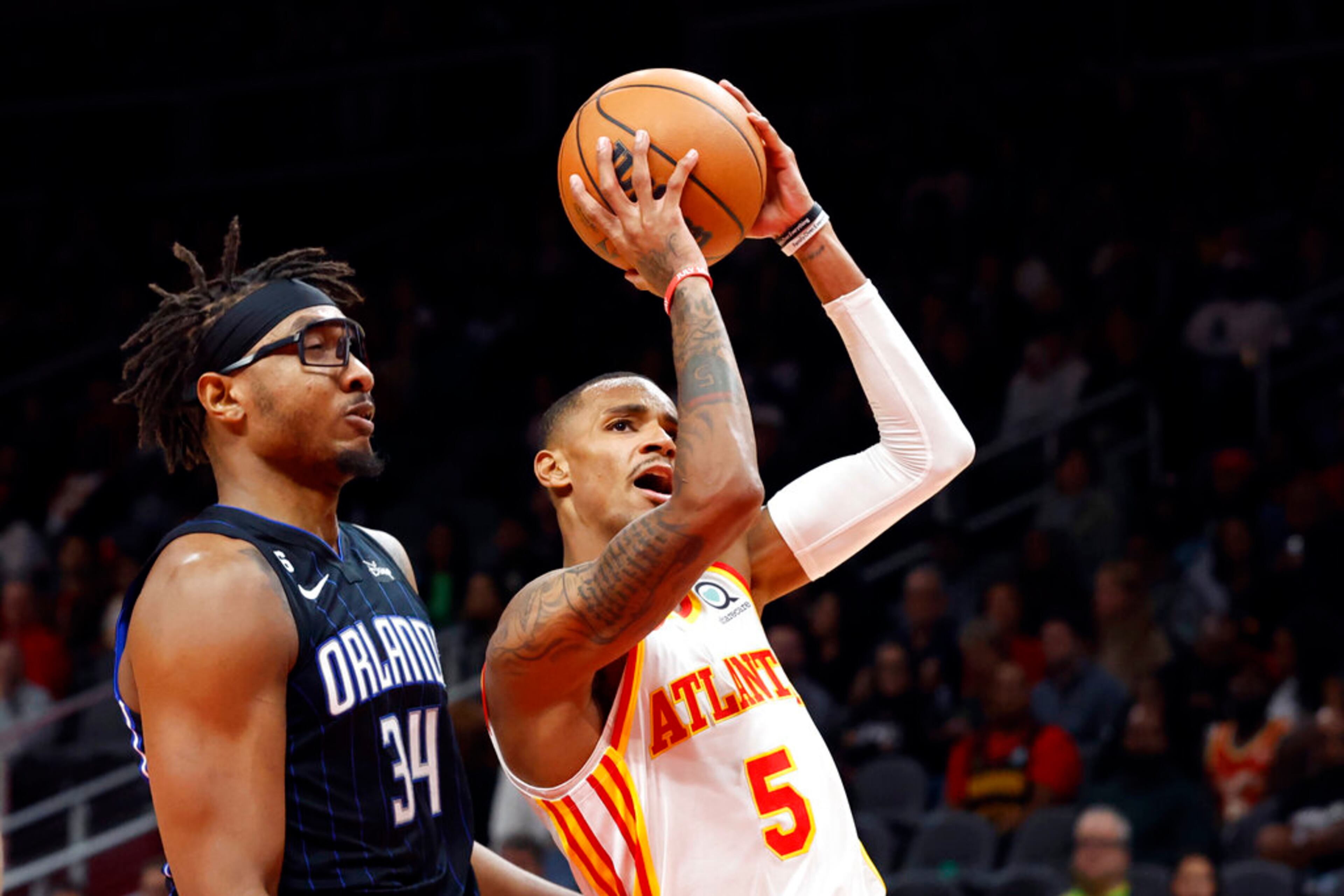 Atlanta Hawks guard Dejounte Murray (5) shoots next to Orlando Magic center Wendell Carter Jr. (34) during the first half of an NBA basketball game Friday, Oct. 21, 2022, in Atlanta. (AP Photo/Butch Dill)
