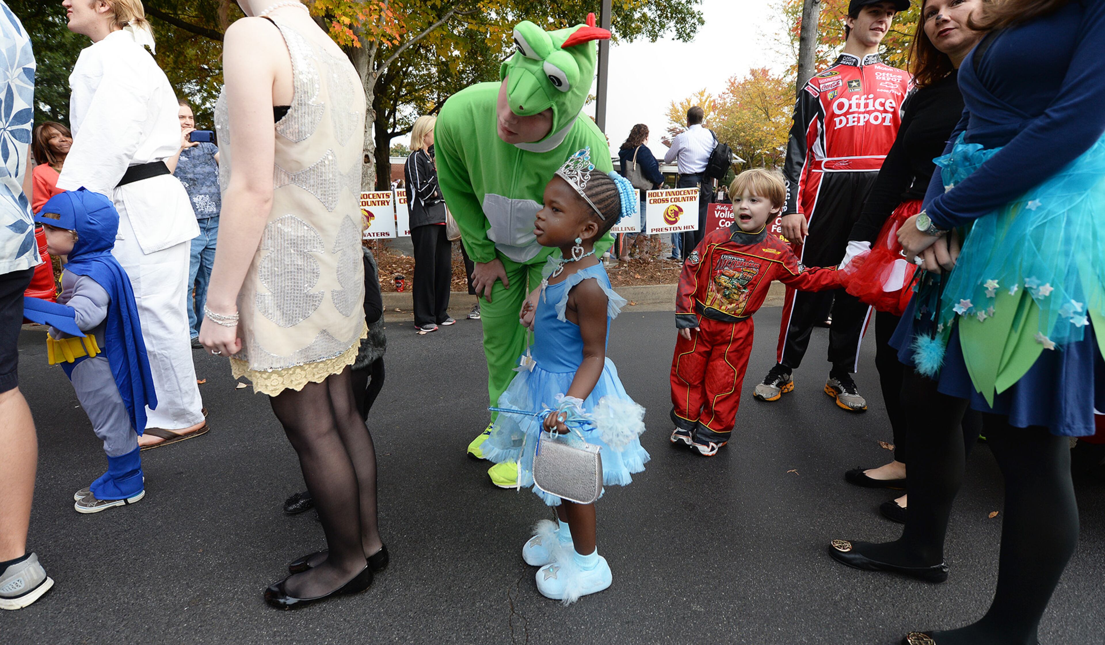 Sara Kimble,4, (center) stands in line with William Boor as they march in Holy Innocents' Episcopal School's annual Halloween Parade on Thursday, October 31, 2013. One hundred fifteen seniors held the hands of 100 primary school kids as they marched in front of students, teachers, parents and friends. This year was the 45th year for the parade at the school founded in 1959. JOHNNY CRAWFORD / JCRAWFORD@AJC.COM