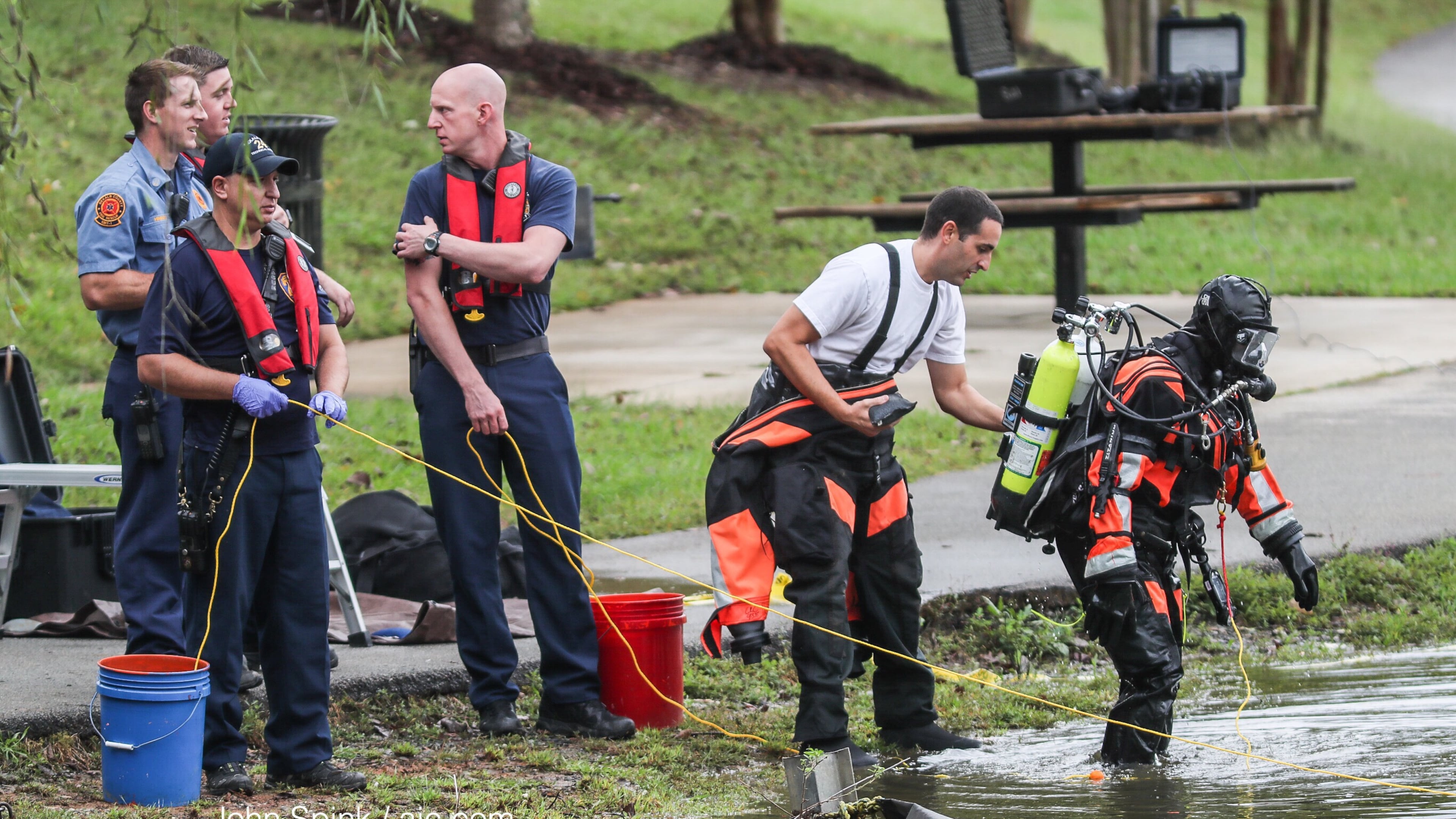 DeKalb County fire and rescue dive members work to pull a car out of McAfee Park Lake in Decatur. The car went in the lake Wednesday, but officials are not yet sure how it got in there. JOHN SPINK/JSPINK@AJC.COM