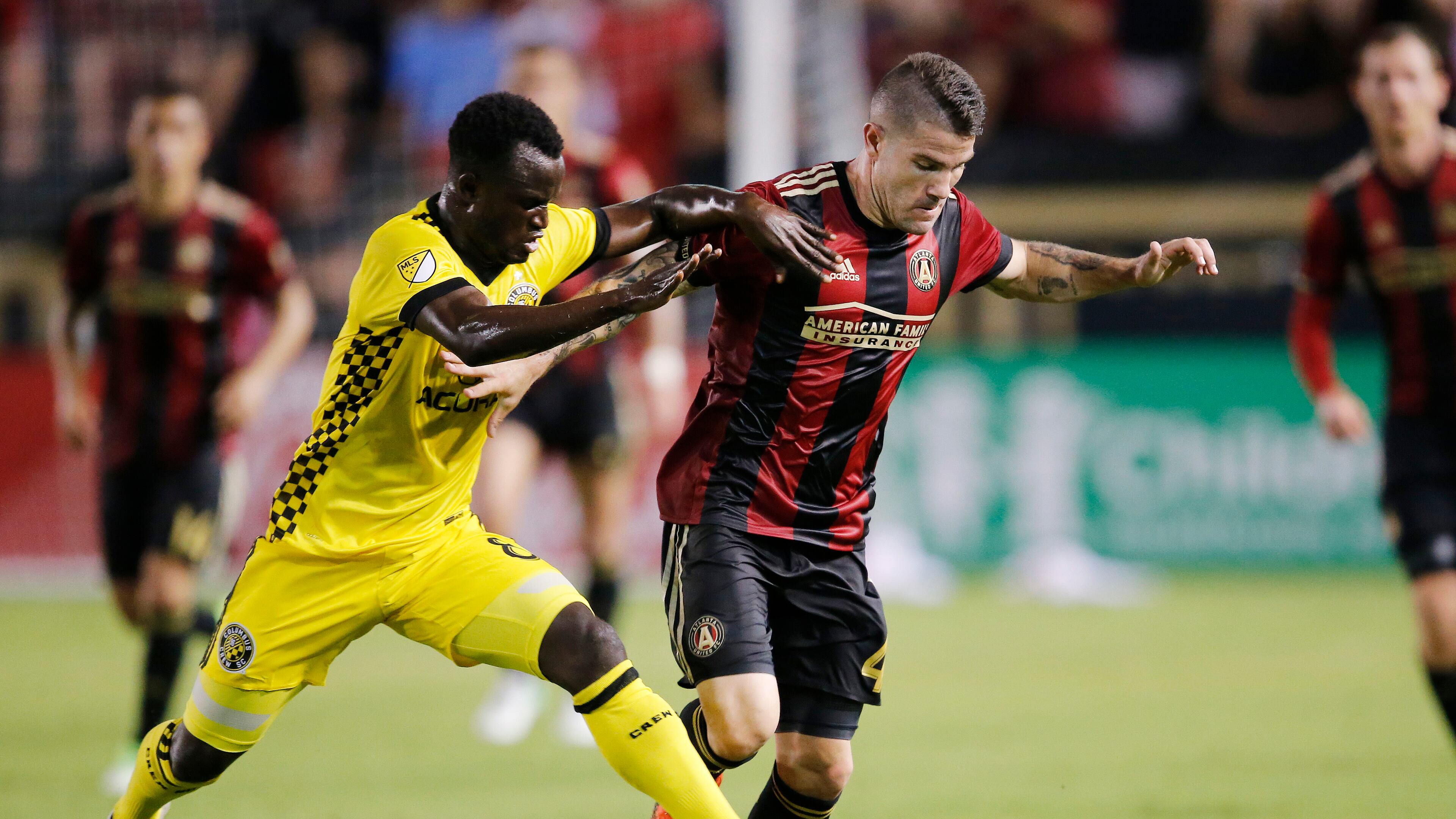 Atlanta United defender Greg Garza (4) is challenged by Columbus Crew midfielder Mohammed Abu (8) in the second half of an MLS soccer match, Saturday, June 17, 2017, in Atlanta . Atlanta won 3-1. (AP Photo/John Bazemore)