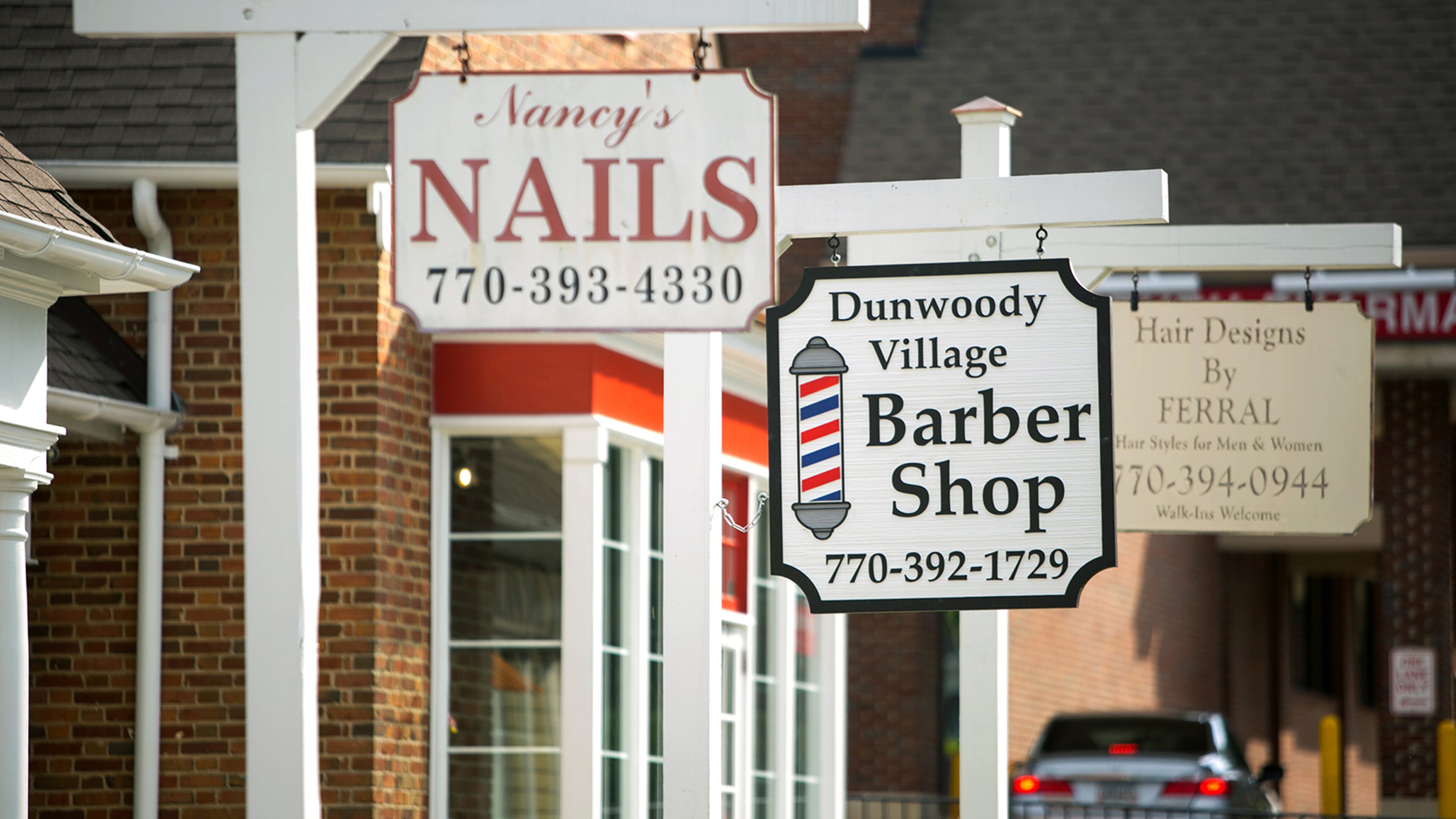 Signs for businesses are shown at Dunwoody Village on Friday, May 15, 2015, in Dunwoody, Ga. PHOTO / JASON GETZ