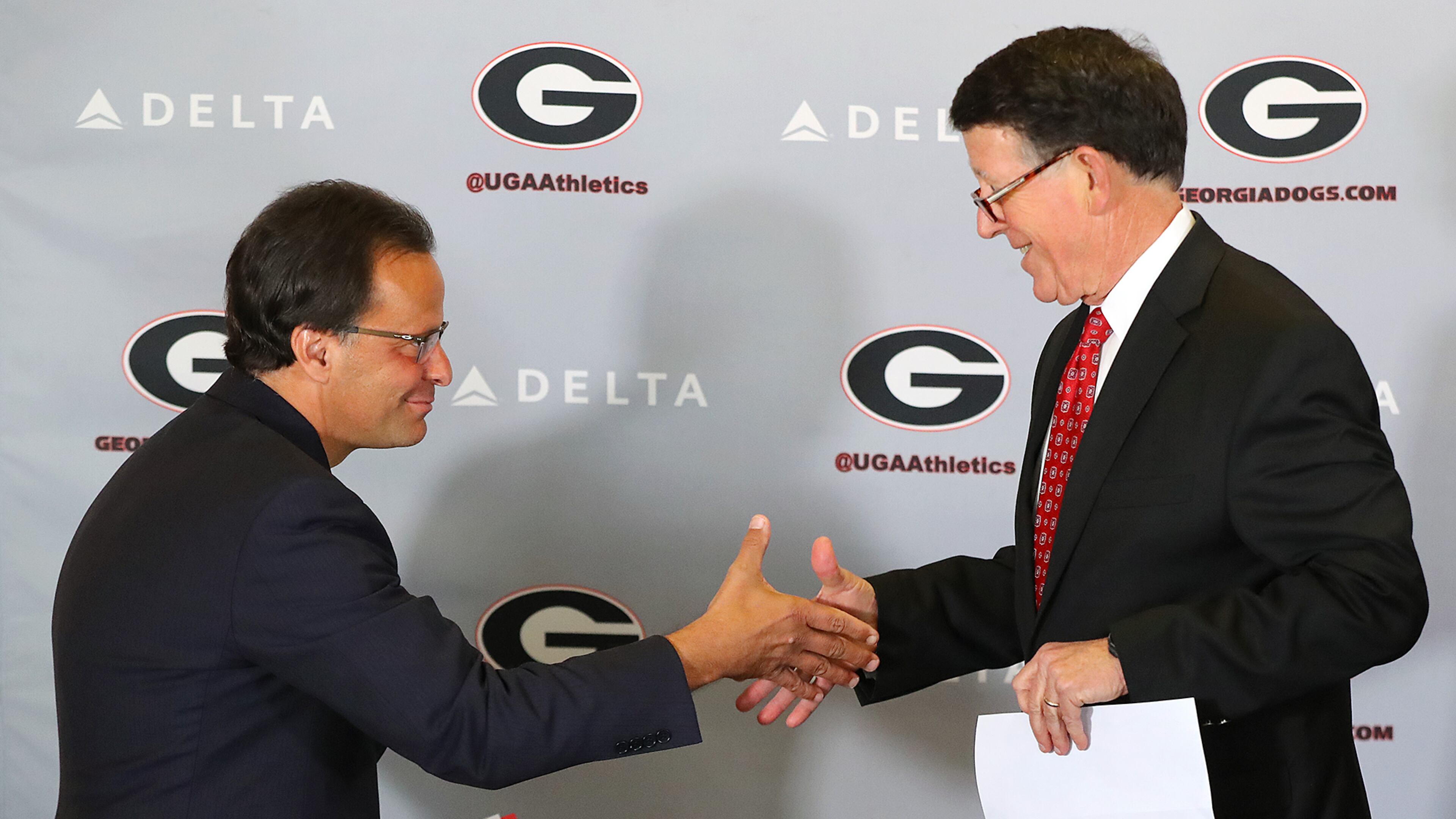 Georgia athletics director Greg McGarity (right) introduces Tom Crean as the new men's basketball head coach at the University of Georgia on Friday, March 16, 2018, at Stegeman Coliseum in Athens. Crean compiled a 356-231 record in 18 seasons at Marquette and Indiana from 1999-2017. Curtis Compton/ccompton@ajc.com