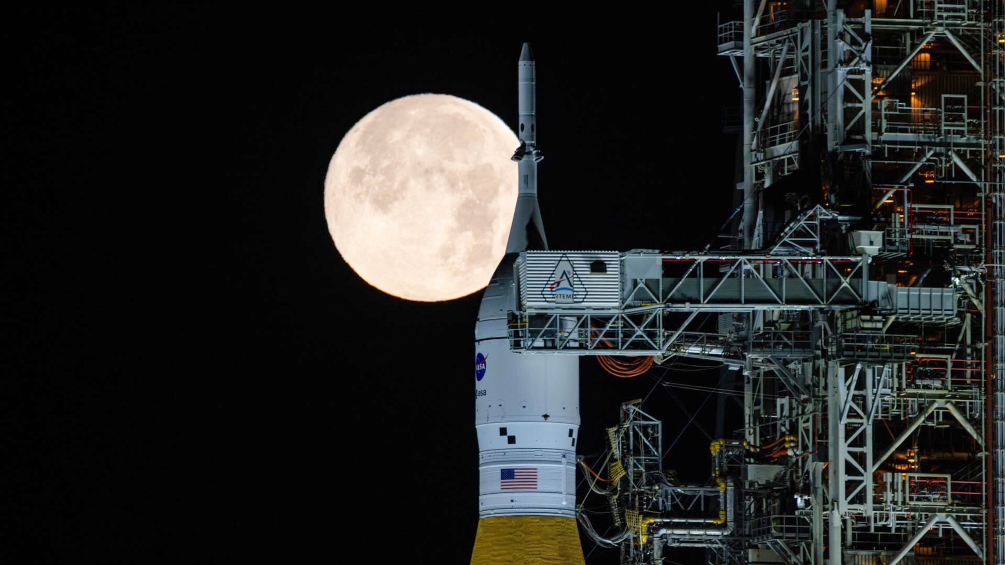 A full moon is seen shining over NASA’s SLS (Space Launch System) and Orion spacecraft, atop the mobile launcher in the early hours of Sunday, Feb. 1, 2026, at NASA’s Kennedy Space Center in Florida. (Sam Lott/NASA via AP)