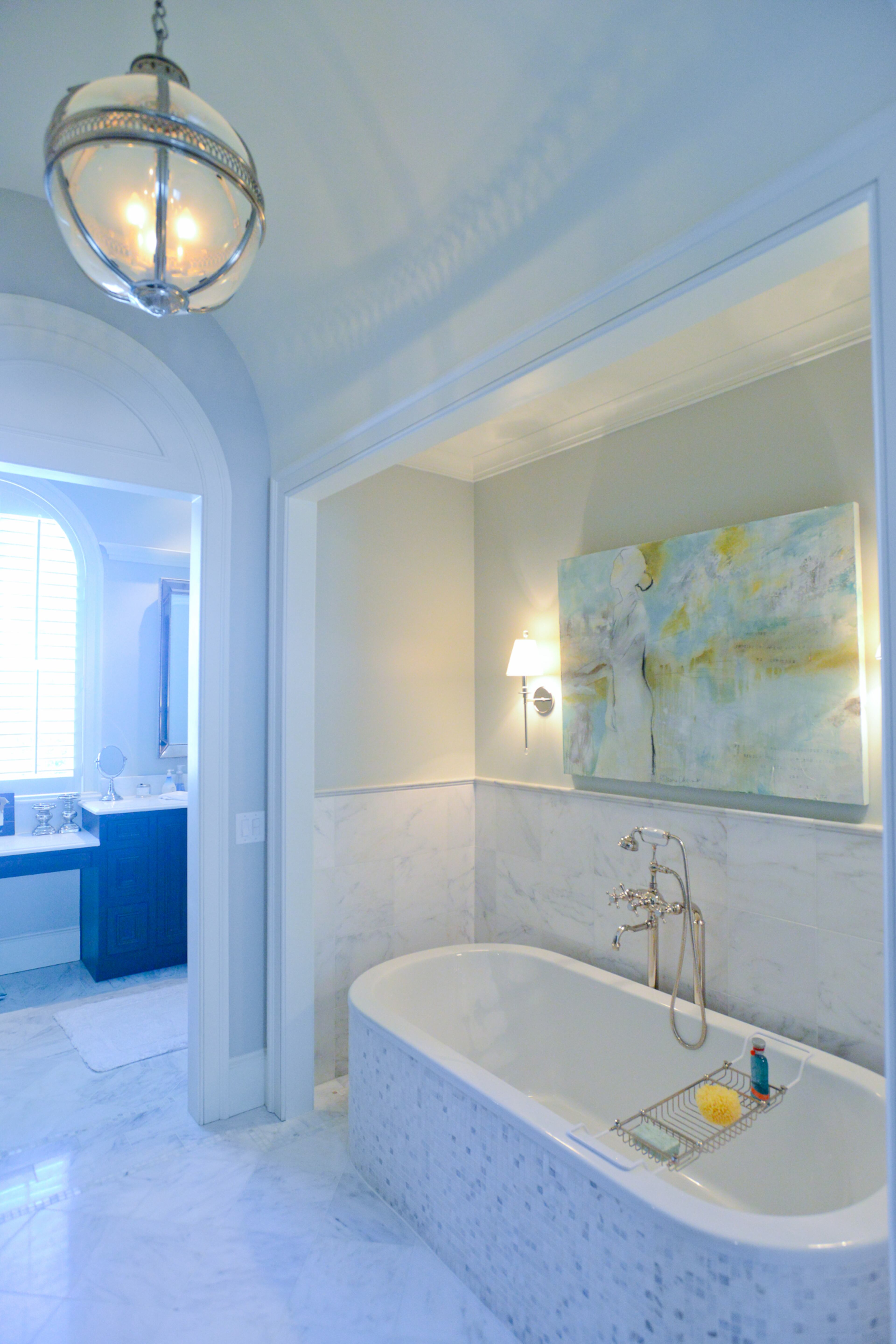 A chandelier by RH (formerly Restoration Hardware) and a tub and stone from Waterworks are features of the large master bathroom in Jamie and David Dean's renovated 1930s home.