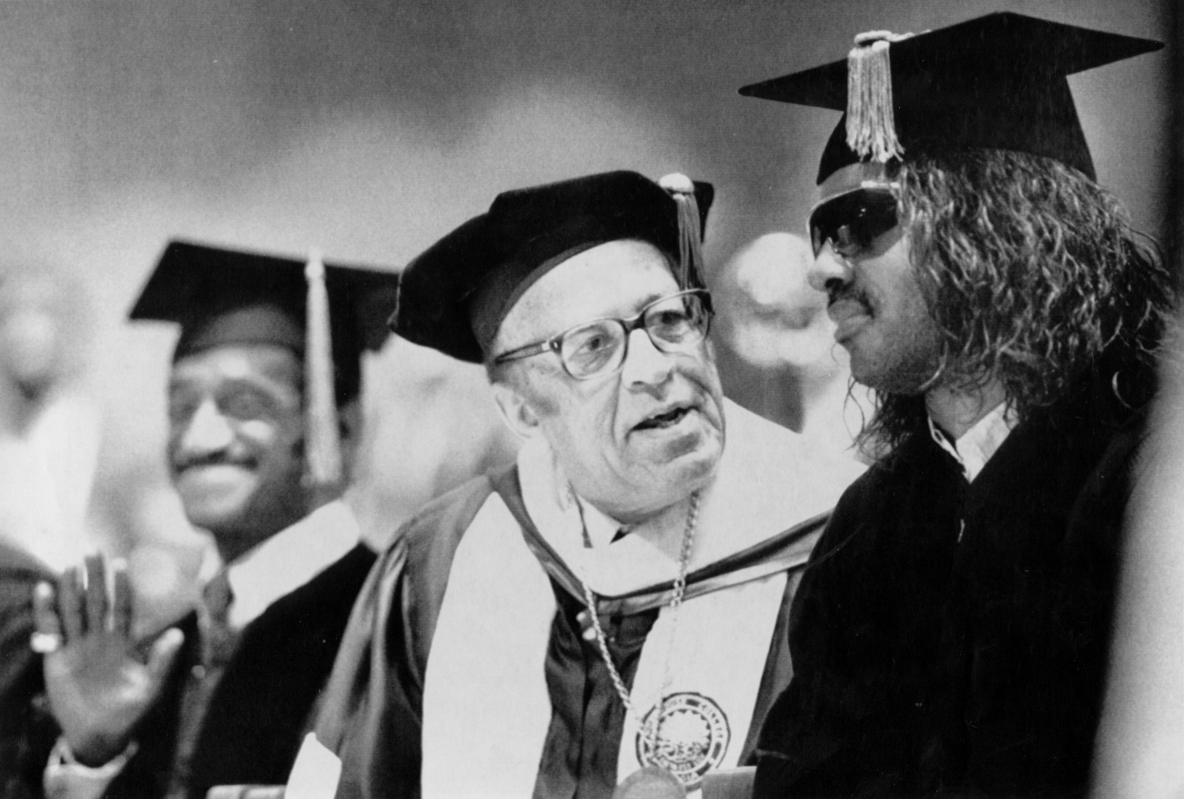 Morehouse College president Hugh Gloster (center) talks with Stevie Wonder (right) while Sammy Davis, Jr. waves to a fan Sunday during graduation ceremonies at Morehouse on May 17, 1987. Wonder and Davis received honorary degrees from the school. Andy Sharp/AJC.