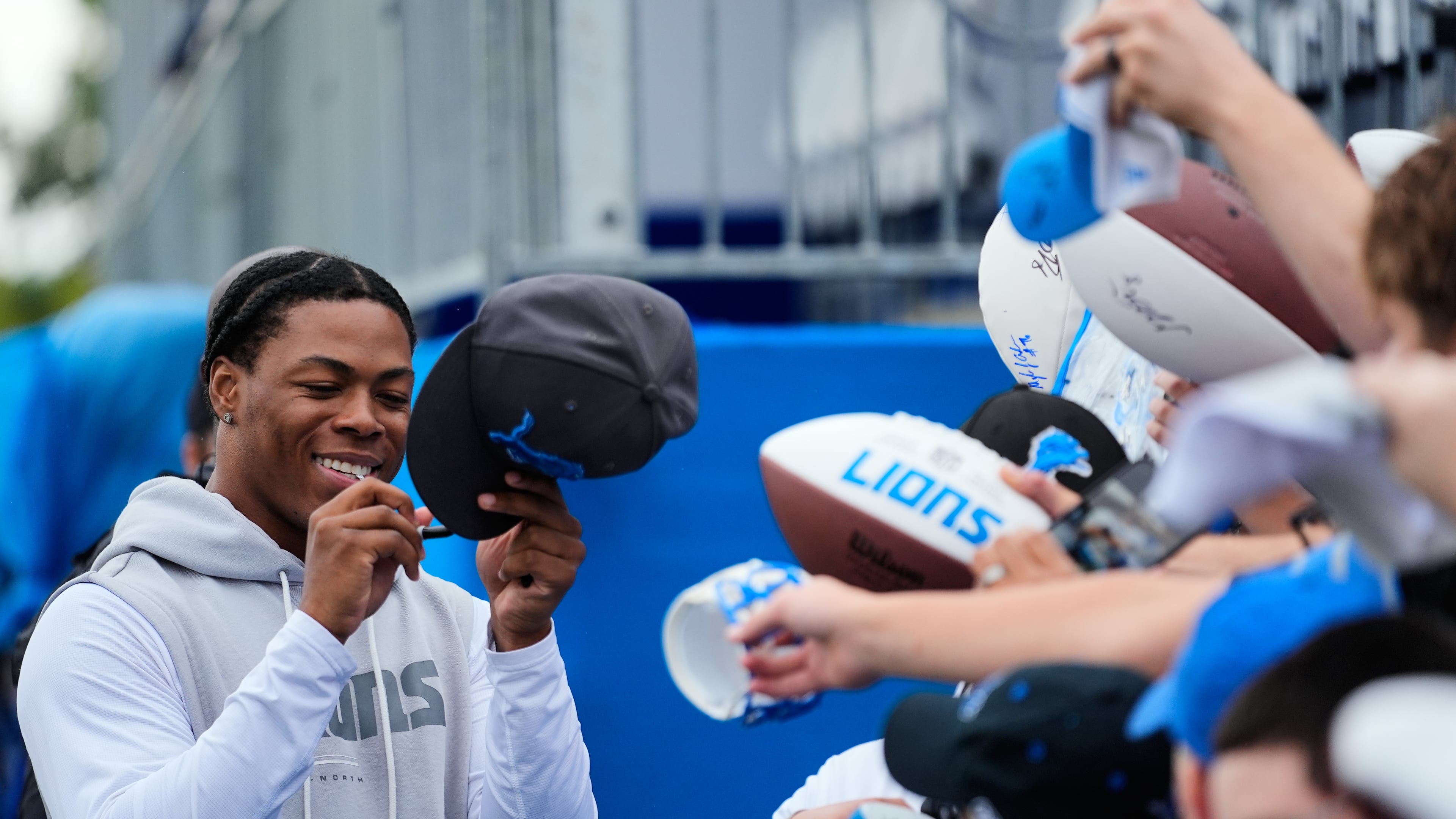 Detroit Lions running back Jahmyr Gibbs signs autographs for fans after practice at the NFL football team's training camp, in Allen Park, Mich., Sunday, Aug. 2, 2026. (AP Photo/Paul Sancya)
