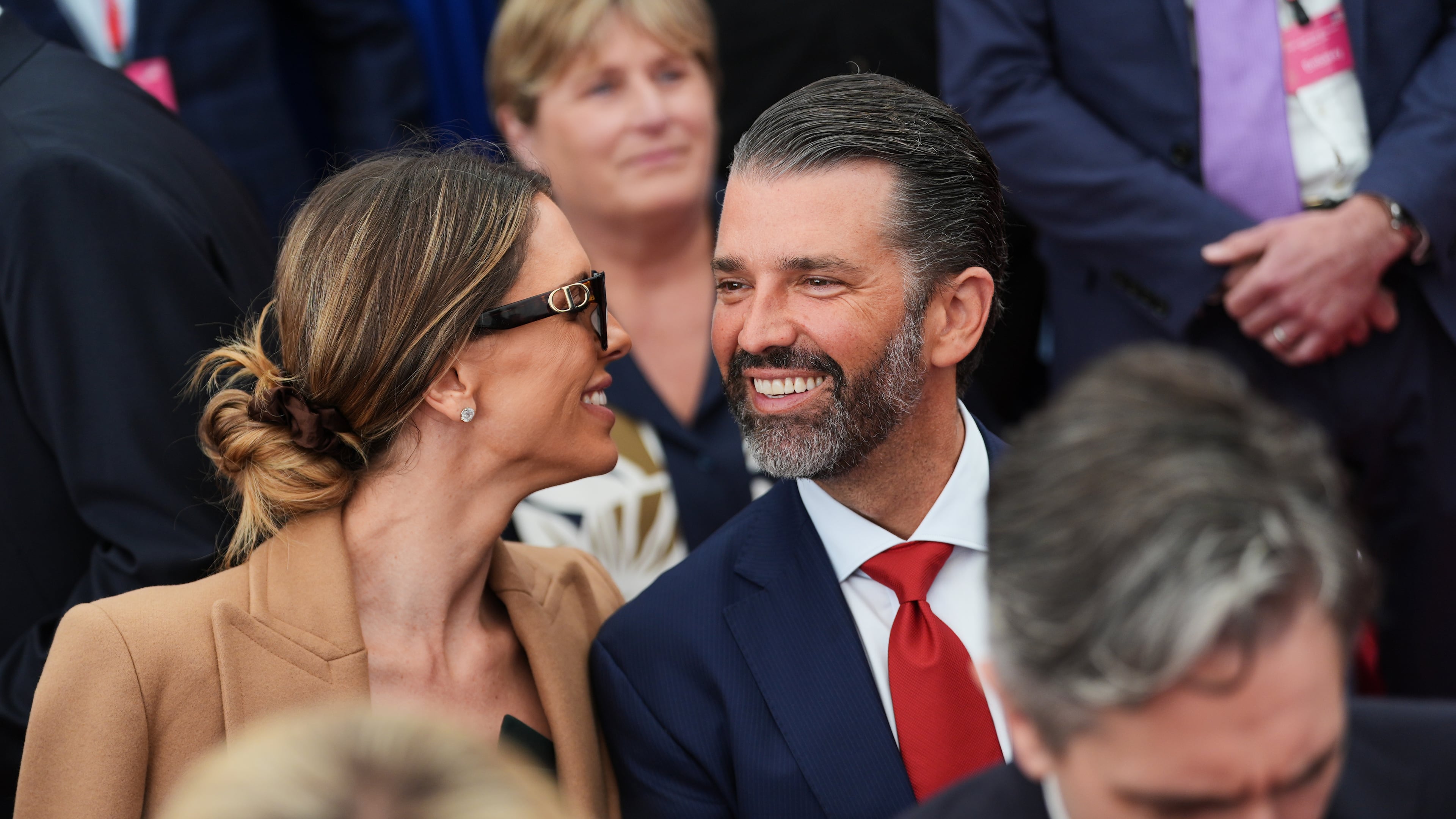 Donald Trump Jr, center, speaks with his wife Bettina, left, as they wait for U.S. President Donald Trump to deliver remarks to U.S. embassy staff at Deerfield Residence in Dublin, Saturday, Sept. 12, 2026. (AP Photo/Julia Demaree Nikhinson)