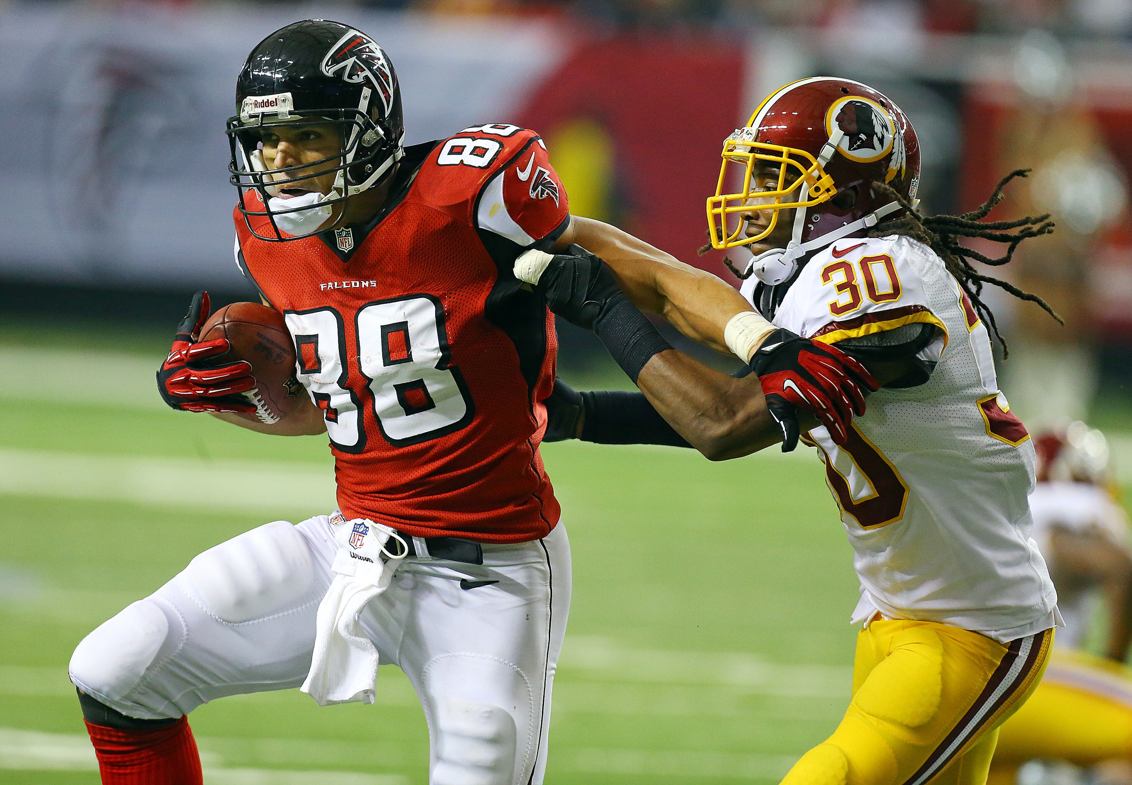 Falcons tight end Tony Gonzalez becomes the 5th player in NFL history to reach 15,000 receiving yards catching a pass against Redskins cornerback E.J. Biggers during the second half of a NFL football game on Sunday, Dec. 15, 2013, in Atlanta.