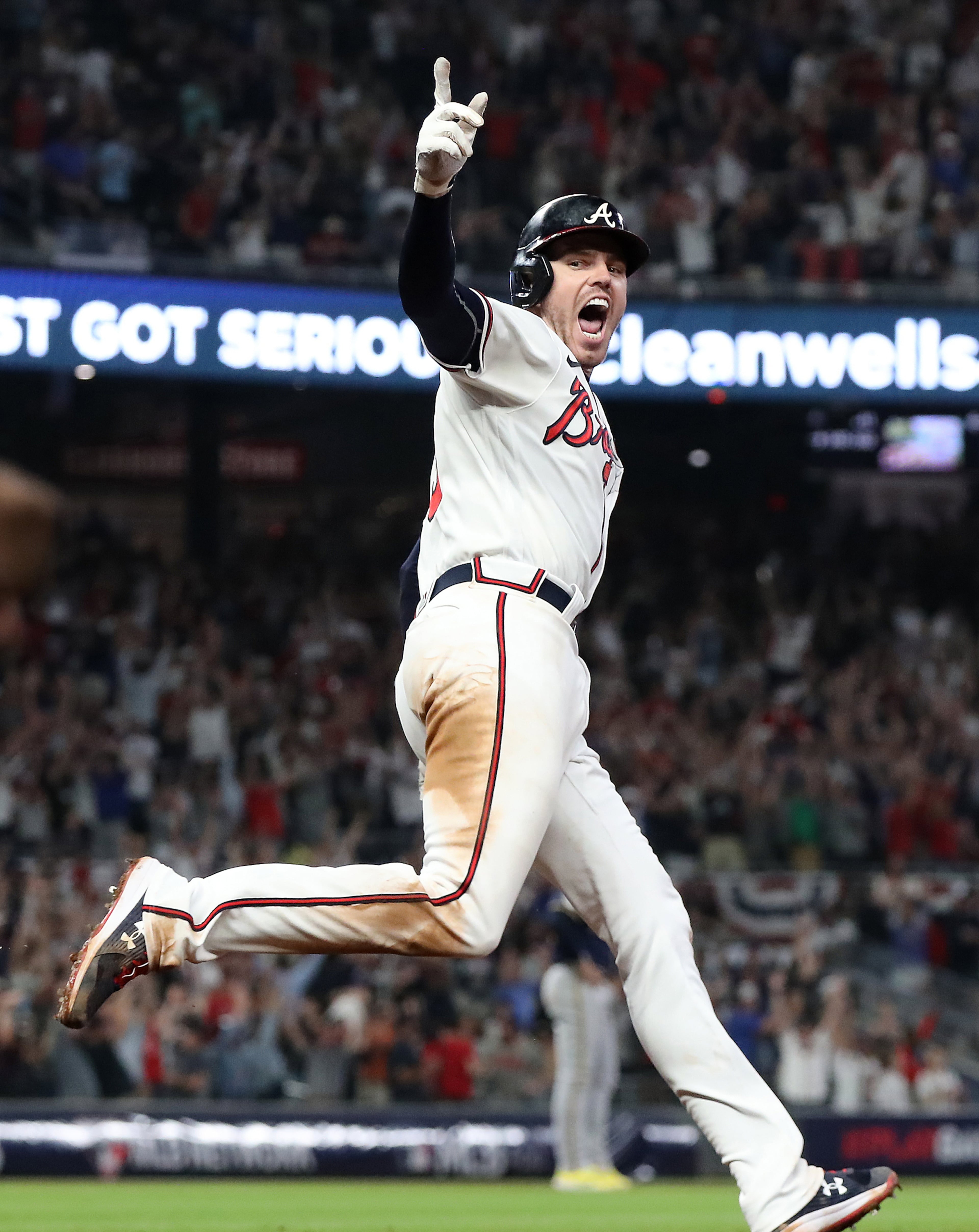 101221 ATLANTA: Atlanta Braves Freddie Freeman rounds first hitting the game winning solo homer for a 5-4 victory over the Milwaukee Brewers during game 4 of their National League Division Series on Tuesday, Oct. 12, 2021, in Atlanta. “Curtis Compton / Curtis.Compton@ajc.com”