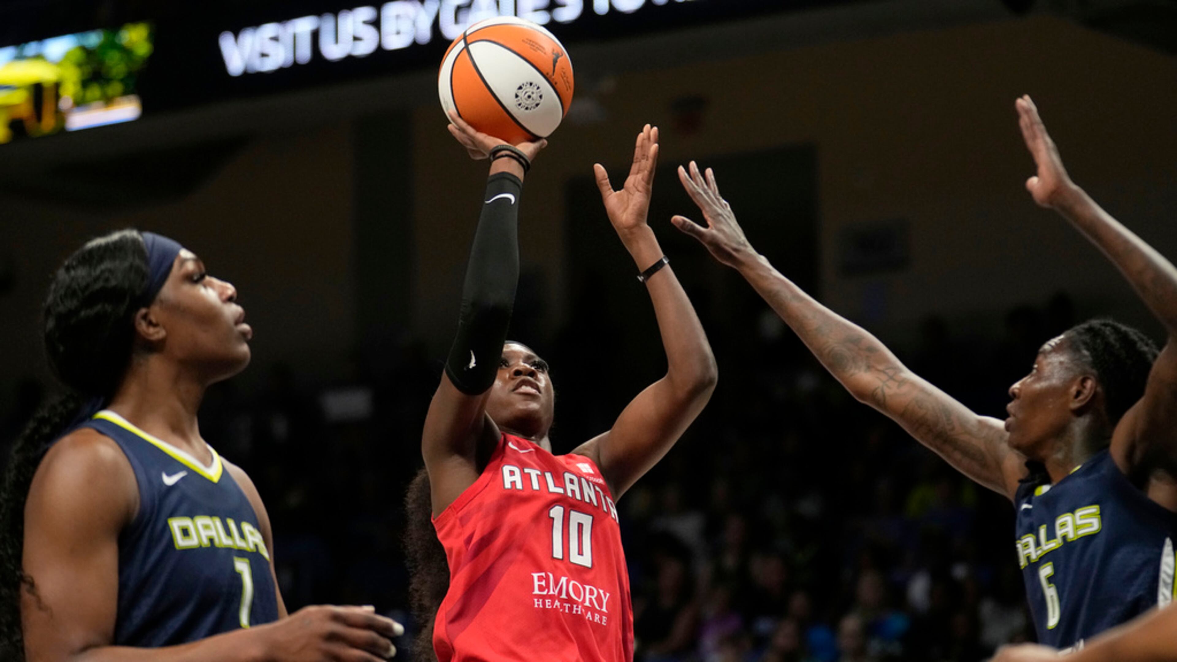 Dream guard Rhyne Howard (10) takes a shot as Dallas Wings' Teaira McCowan, left, and Natasha Howard (6) defend in the first half of Game 2 of a first-round WNBA basketball playoff series, Tuesday, Sept. 19, 2023, in Arlington, Texas. (AP Photo/Tony Gutierrez)
