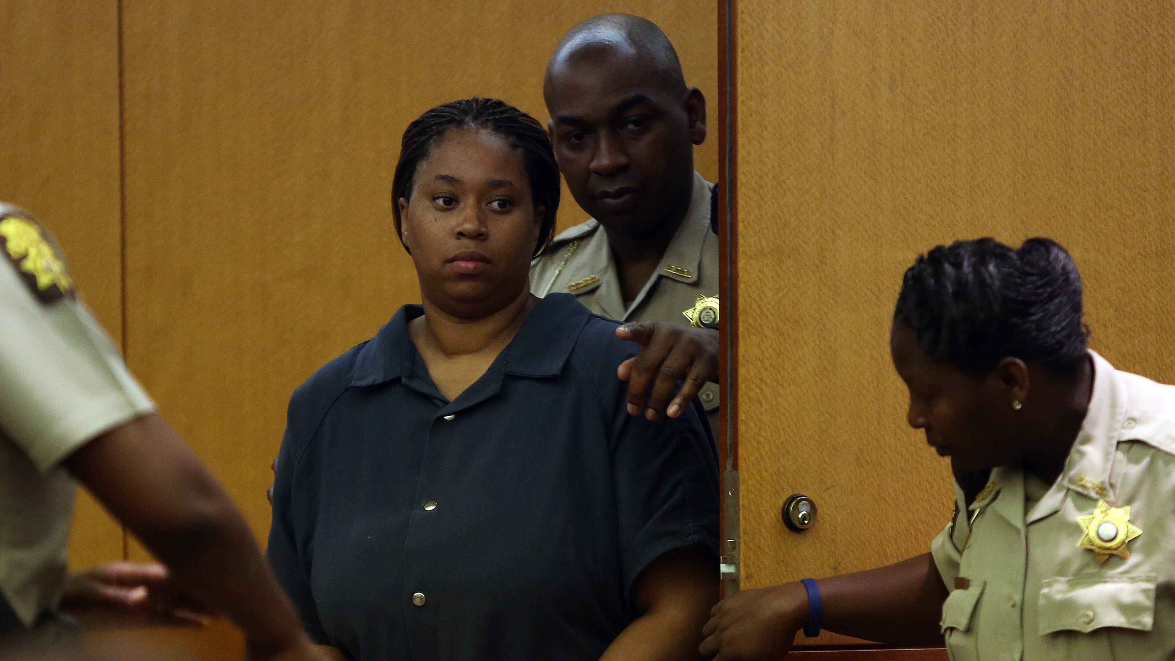 Danielle Parker is led into Fulton County Judge Karen Woodson's courtroom on Wednesday July 31, 2013, for a probable cause hearing in the murder of East Point Police Officer Crystal Parker.