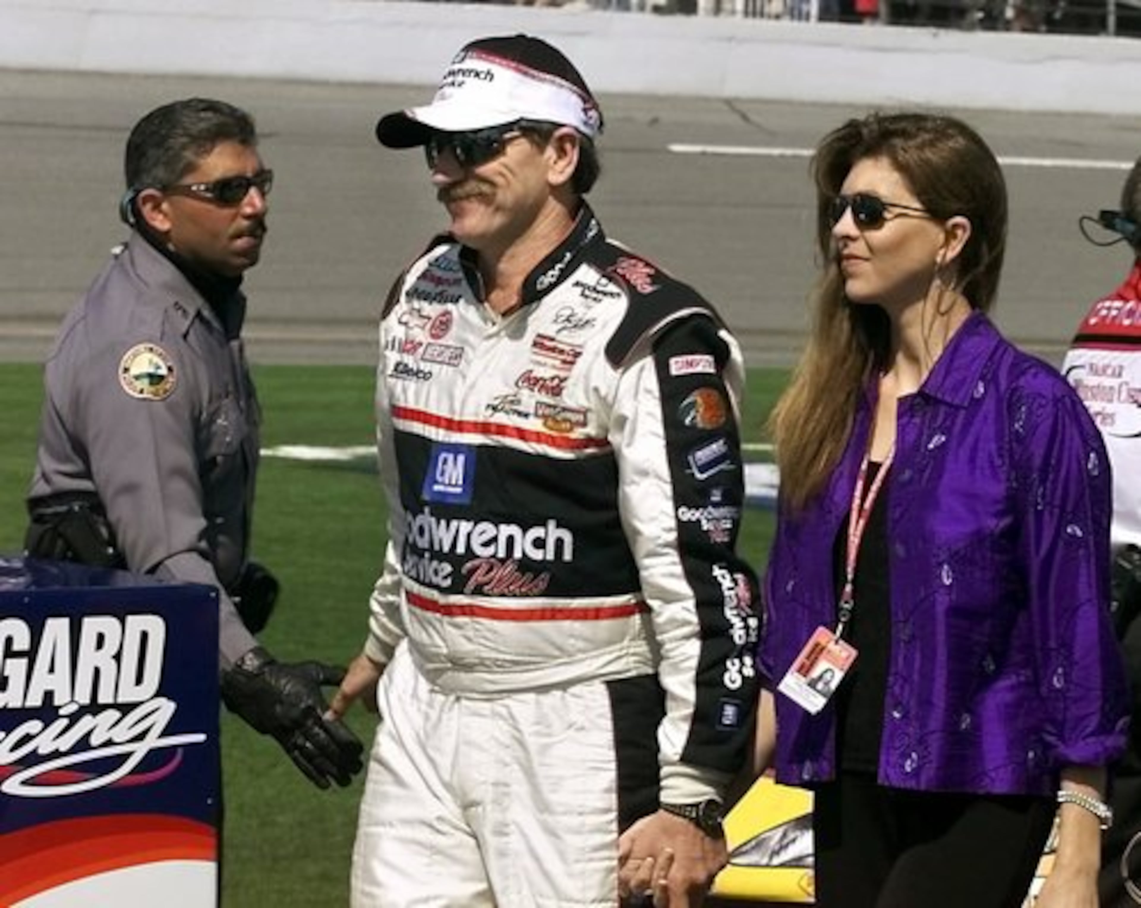 A relaxed Dale Earnhardt Sr. walks down pit row whit his wife, Teresa, and shaking the hand of a Daytona Beach police officer just prior to the start of the 2001 Daytona 500.