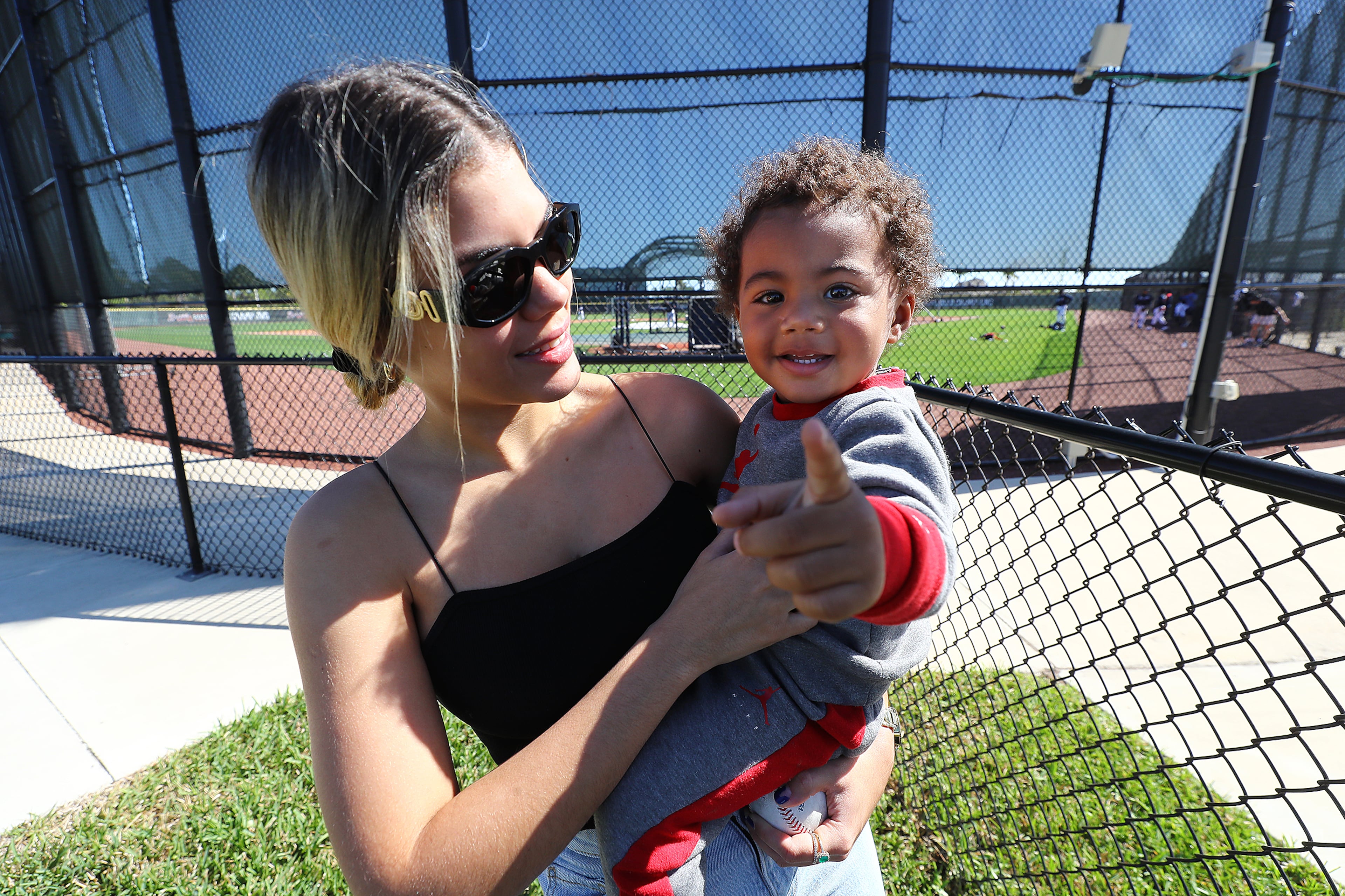 Braves outfielder Ronald Acuna's partner Maria Laborde holds their son Ronald Acuna Jr. II while his dad gets in some batting practice during Spring Training on Thursday, March 17, 2022, in North Port. “Curtis Compton / Curtis.Compton@ajc.com”