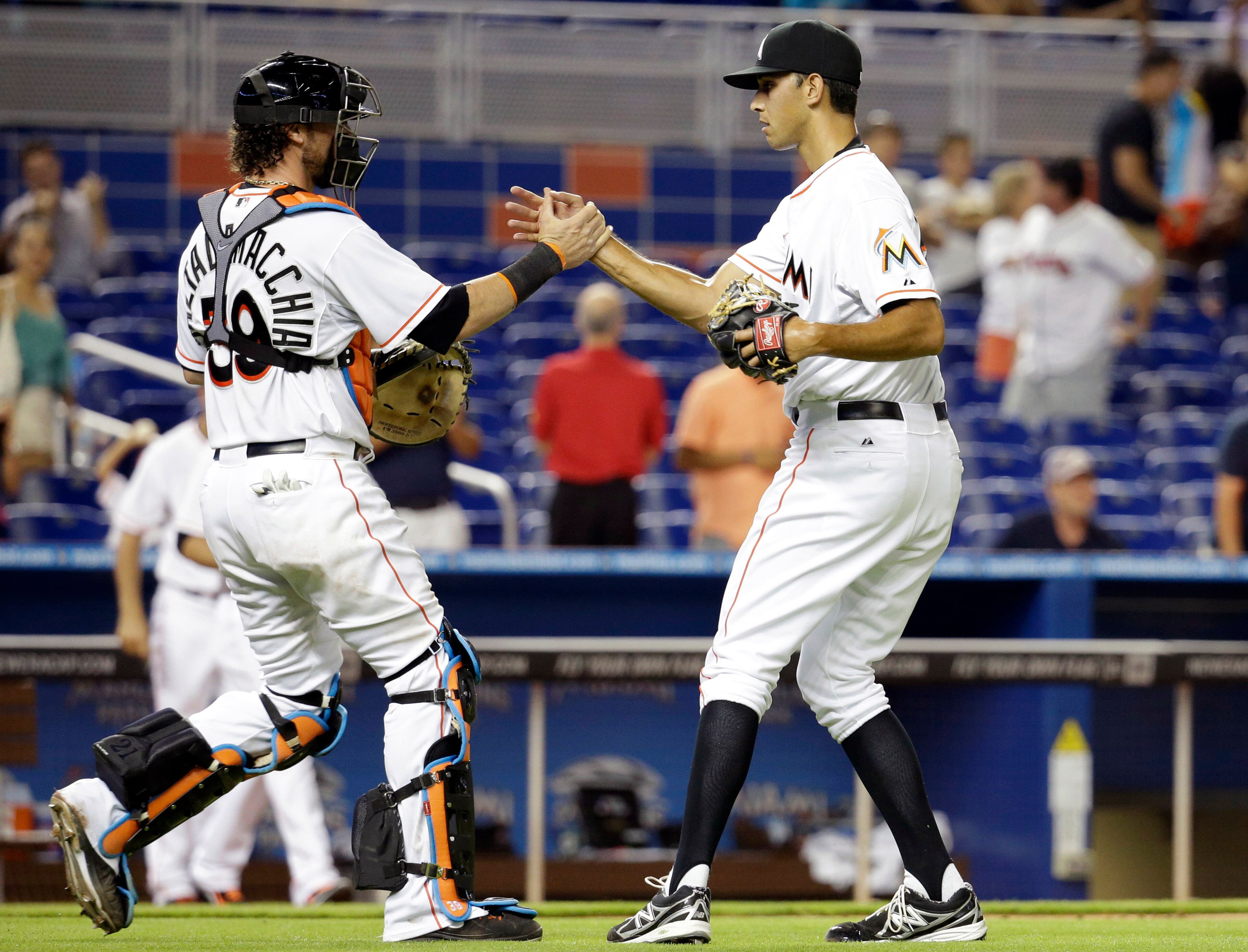 Miami Marlins relief pitcher Steve Cishek, right, shakes hands with catcher Jarrod Saltalamacchia (39) after they defeated the Atlanta Braves 5-4 in a baseball game on Thursday, May 1, 2014, in Miami. (AP Photo/Lynne Sladky)