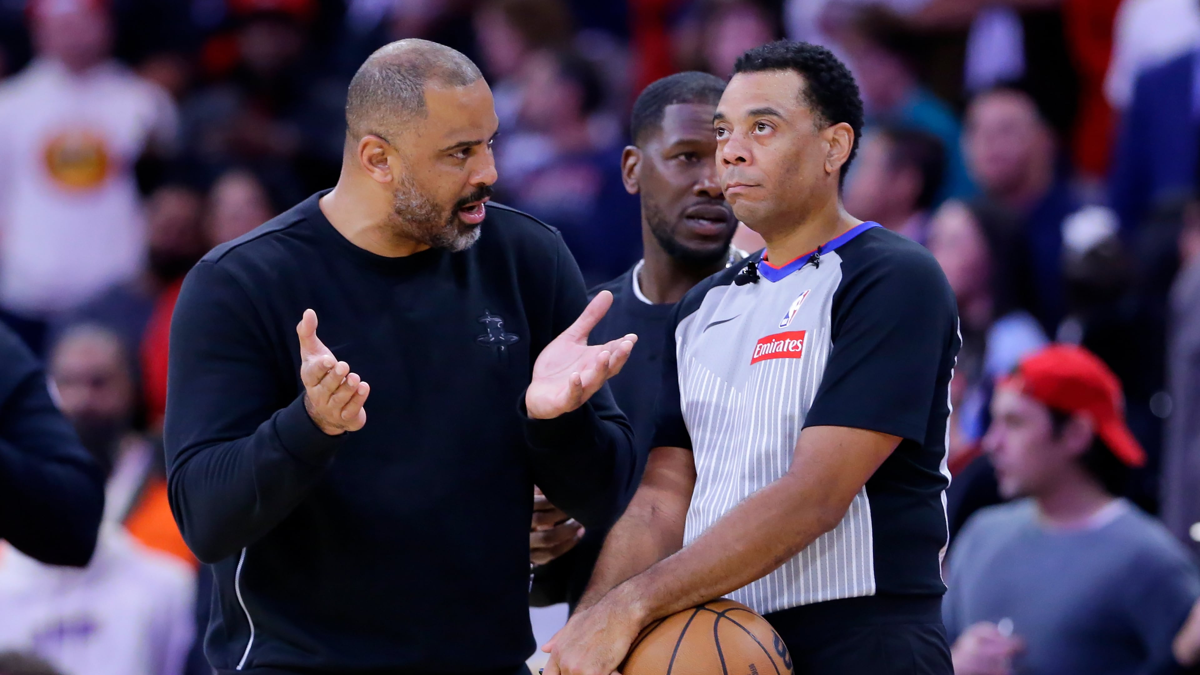 Houston Rockets head coach Ime Udoka, left, appeals to official Kari Lane, right, as a possible flagrant foul call against Jabari Smith Jr. is reviewed in the last 14 seconds of the second half of an NBA basketball game against the LA Clippers Thursday, Dec. 11, 2025, in Houston. (AP Photo/Michael Wyke)