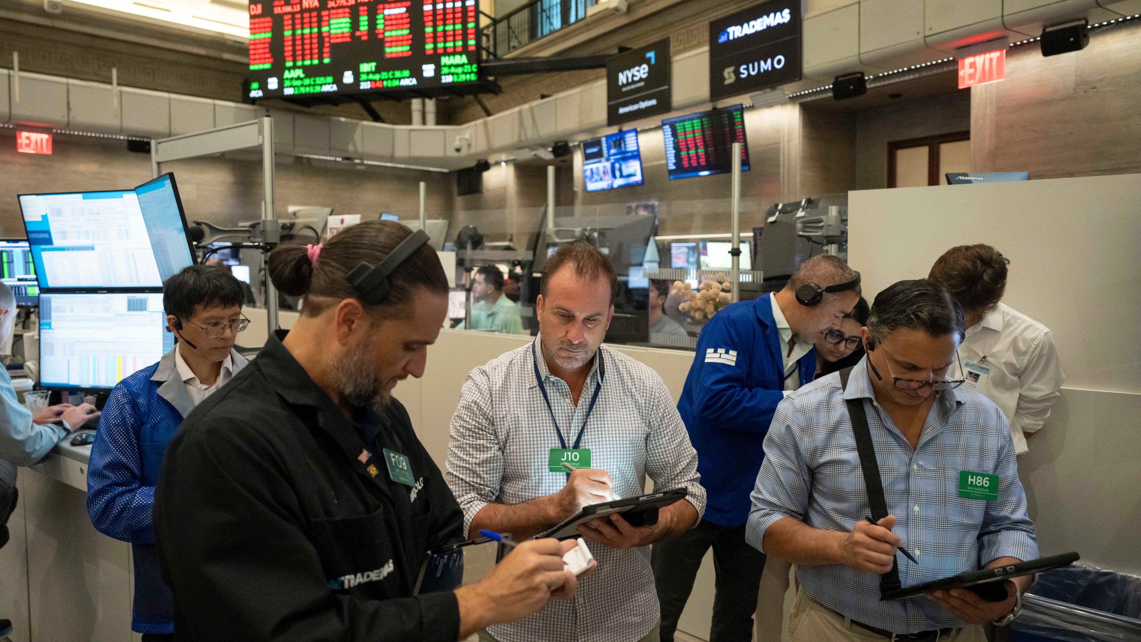 Options traders Chris Dattolo, Scott Frinzi, and Ravi Bhandari, left to right, work on the floor of the New York Stock Exchange, Monday, Aug. 17, 2026, in New York. (AP Photo/Yuki Iwamura)