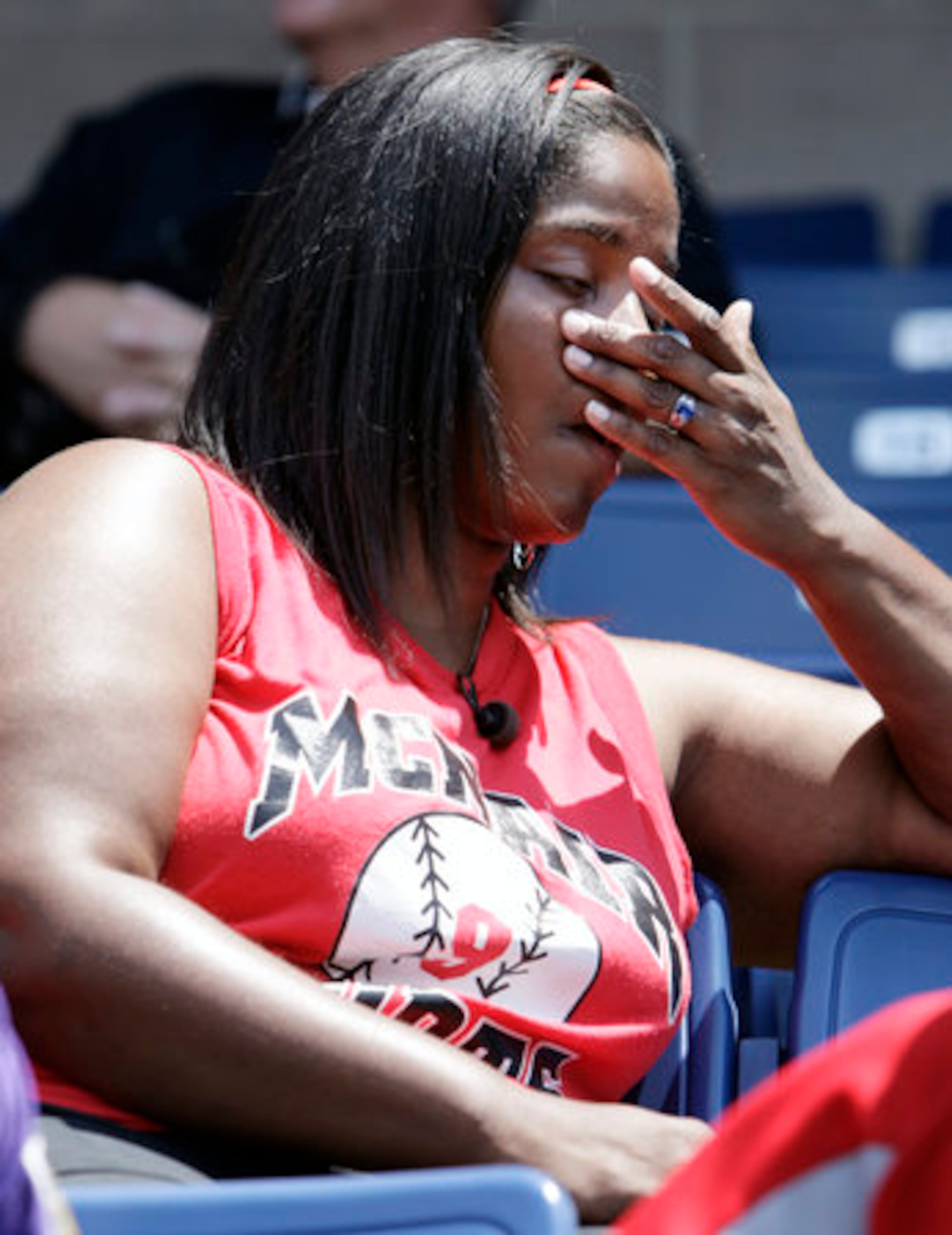 Anissa Rhodes wipes away tears as she watches a video about the career of Steve McNair at LP Field in Nashville on Wednesday. The stadium was open to fans to see photos and videos of the star, and leave condolences.
