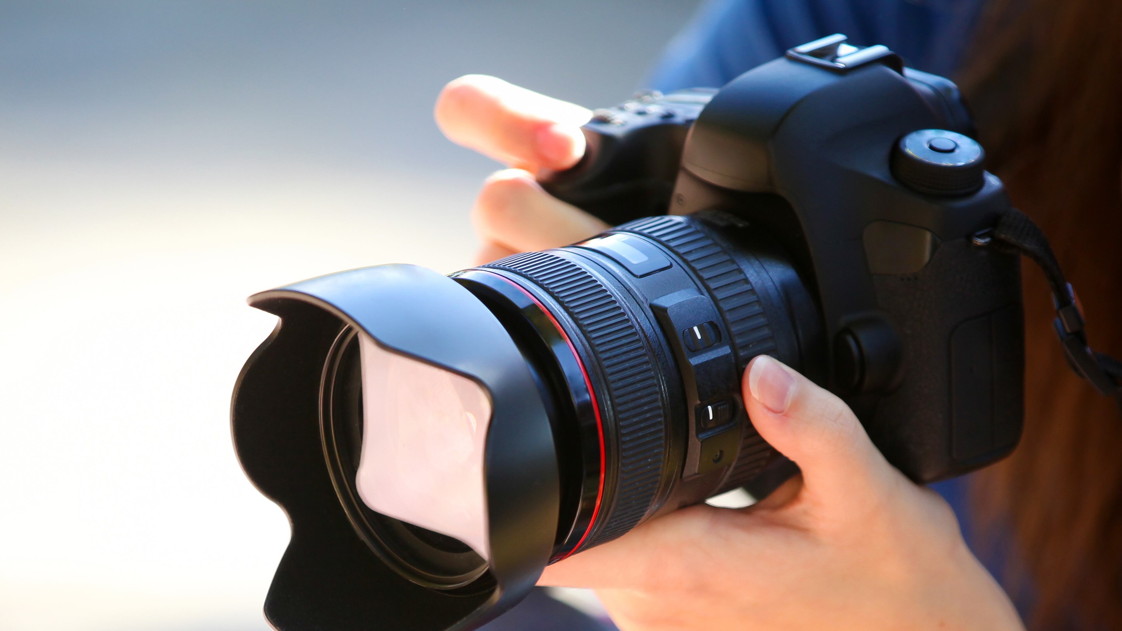 A Young Woman Holding a Full Frame Camera.