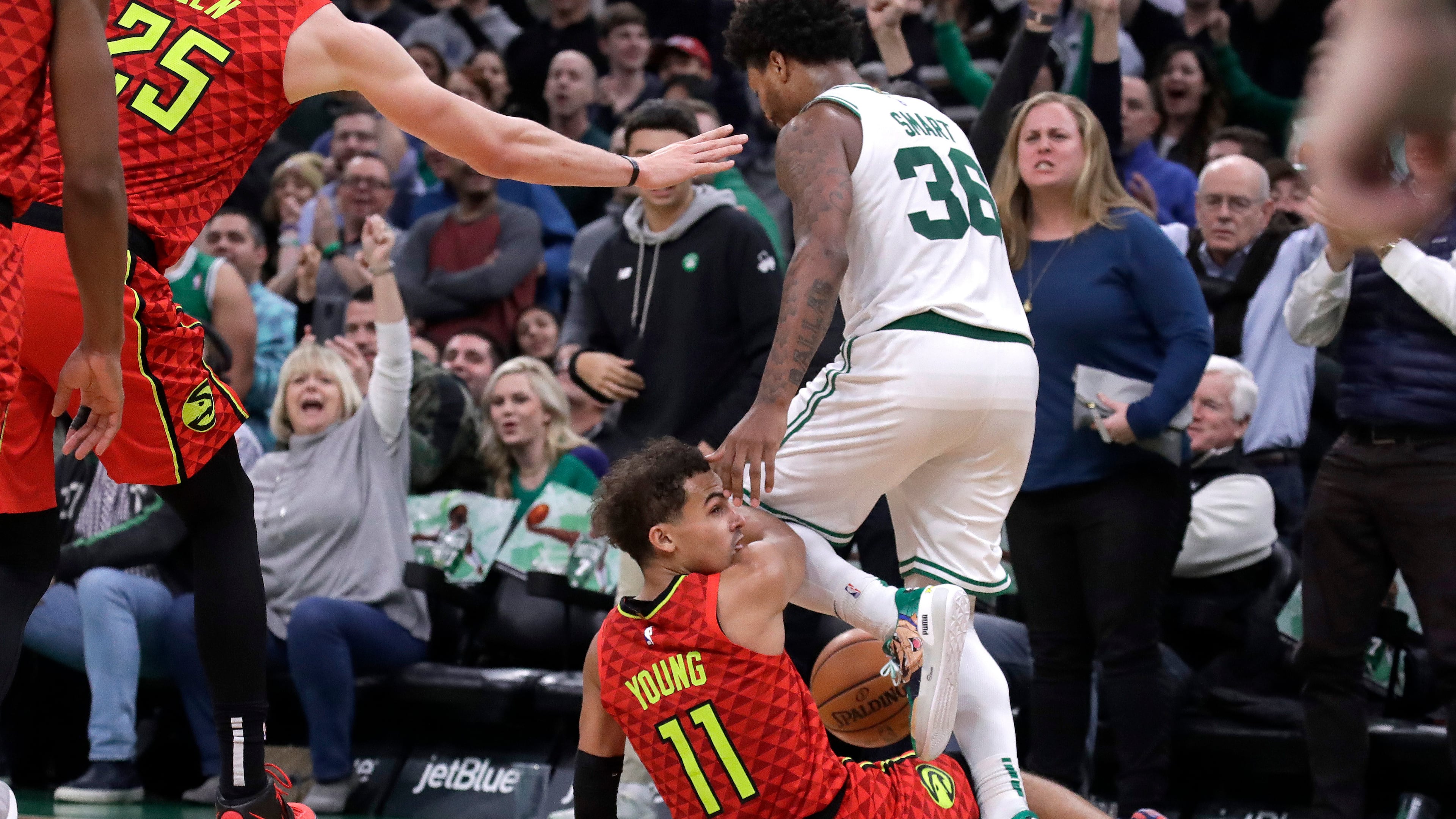 Boston Celtics guard Marcus Smart (36) steps over Hawks guard Trae Young (11), leading to a scuffle in the last seconds of an NBA basketball game Friday, Jan. 3, 2020, in Boston. The Celtics won 109-106. (AP Photo/Elise Amendola)