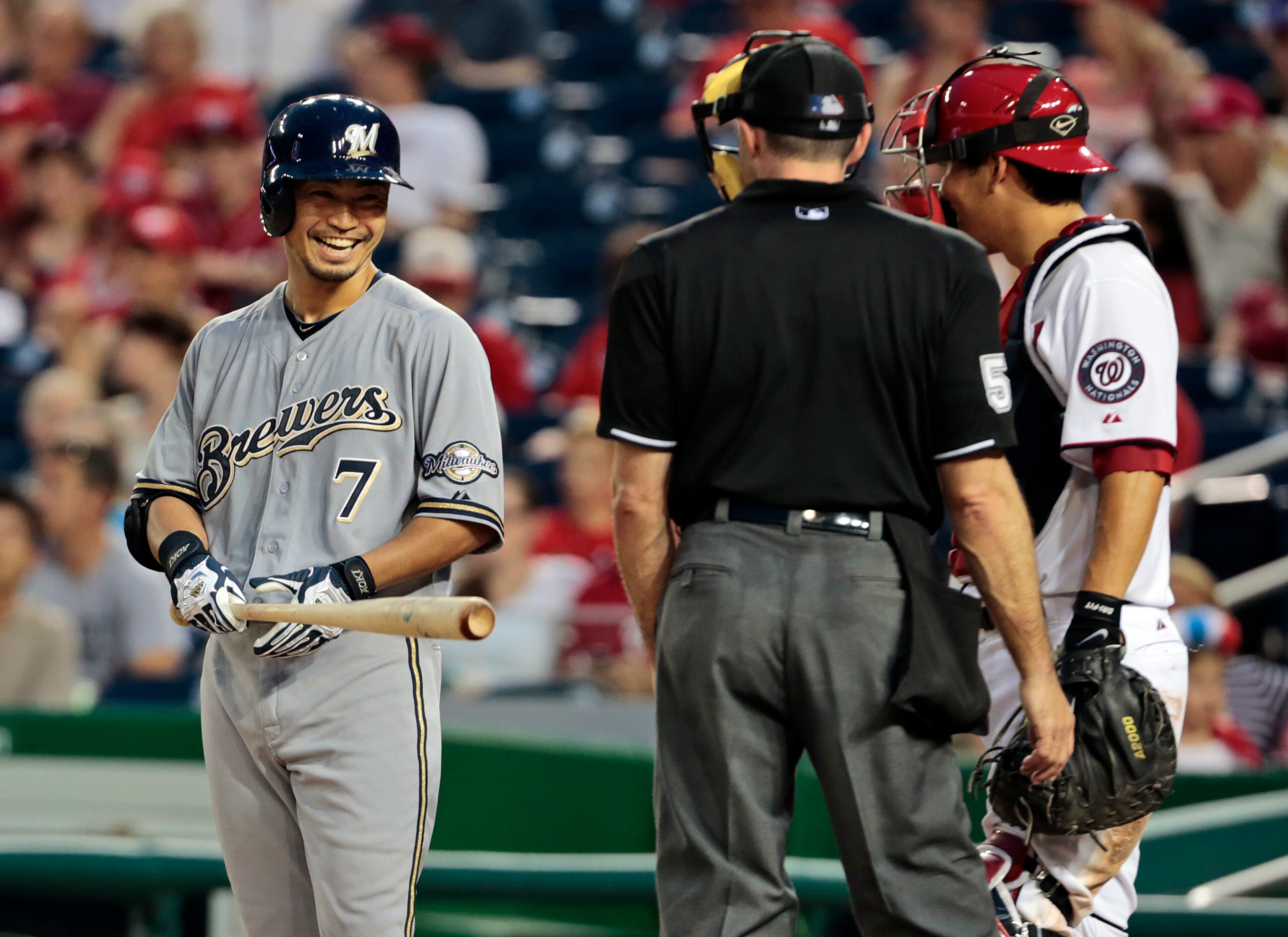 Milwaukee Brewers' Norichika Aoki, left, smiles as he talks with umpire Dan Iassogna, center, and Washington Nationals catcher Kurt Suzuki during the ninth inning of a baseball game at Nationals Park, Wednesday, July 3, 2013, in Washington. The Brewers won 4-1. (AP Photo/Alex Brandon)