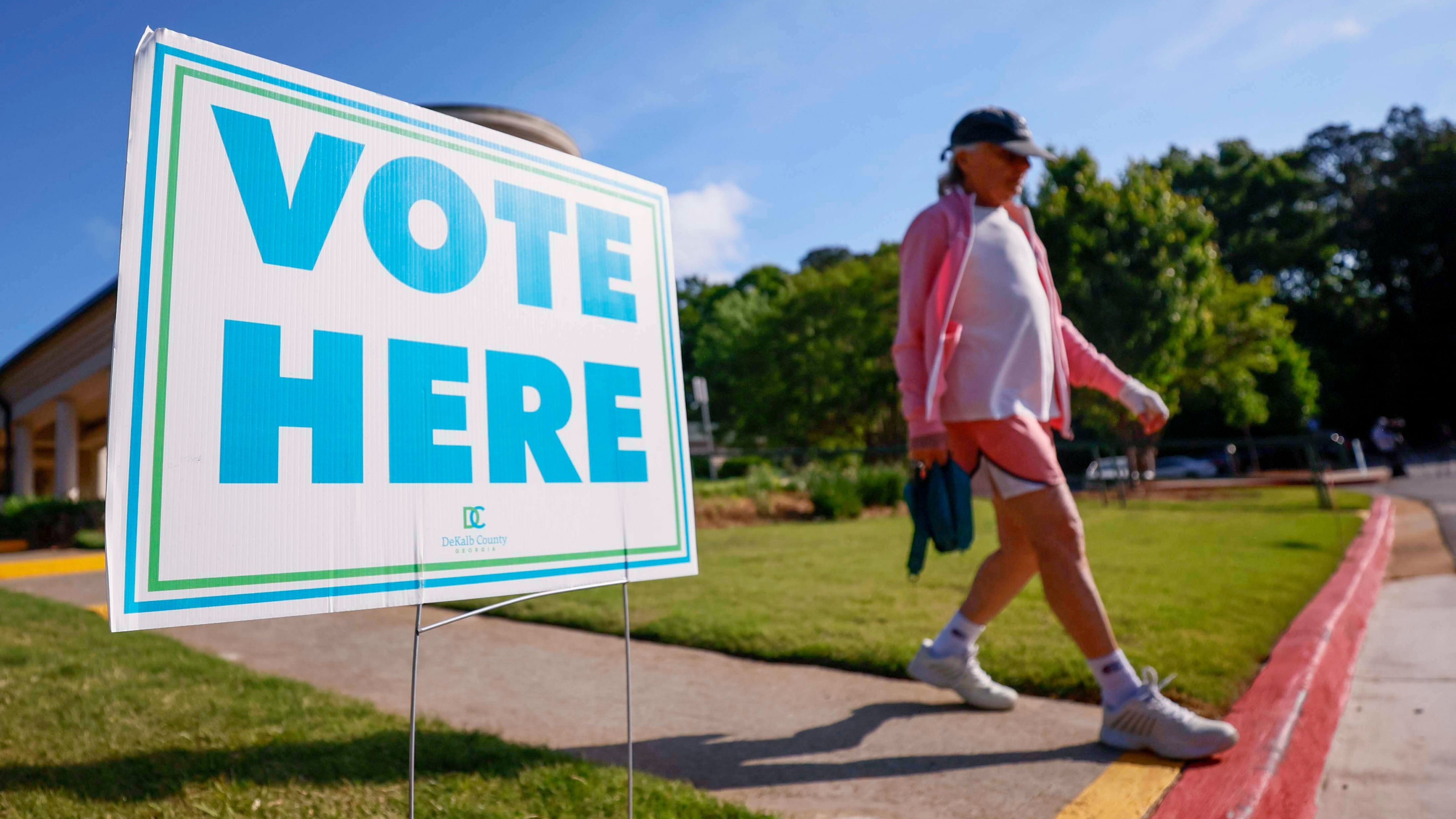 A person walks past a voting sign during the first day of early voting for the primary elections at the Dunwoody Library in Atlanta, Monday, April 27, 2026. (Miguel Martinez/Atlanta Journal-Constitution via AP)