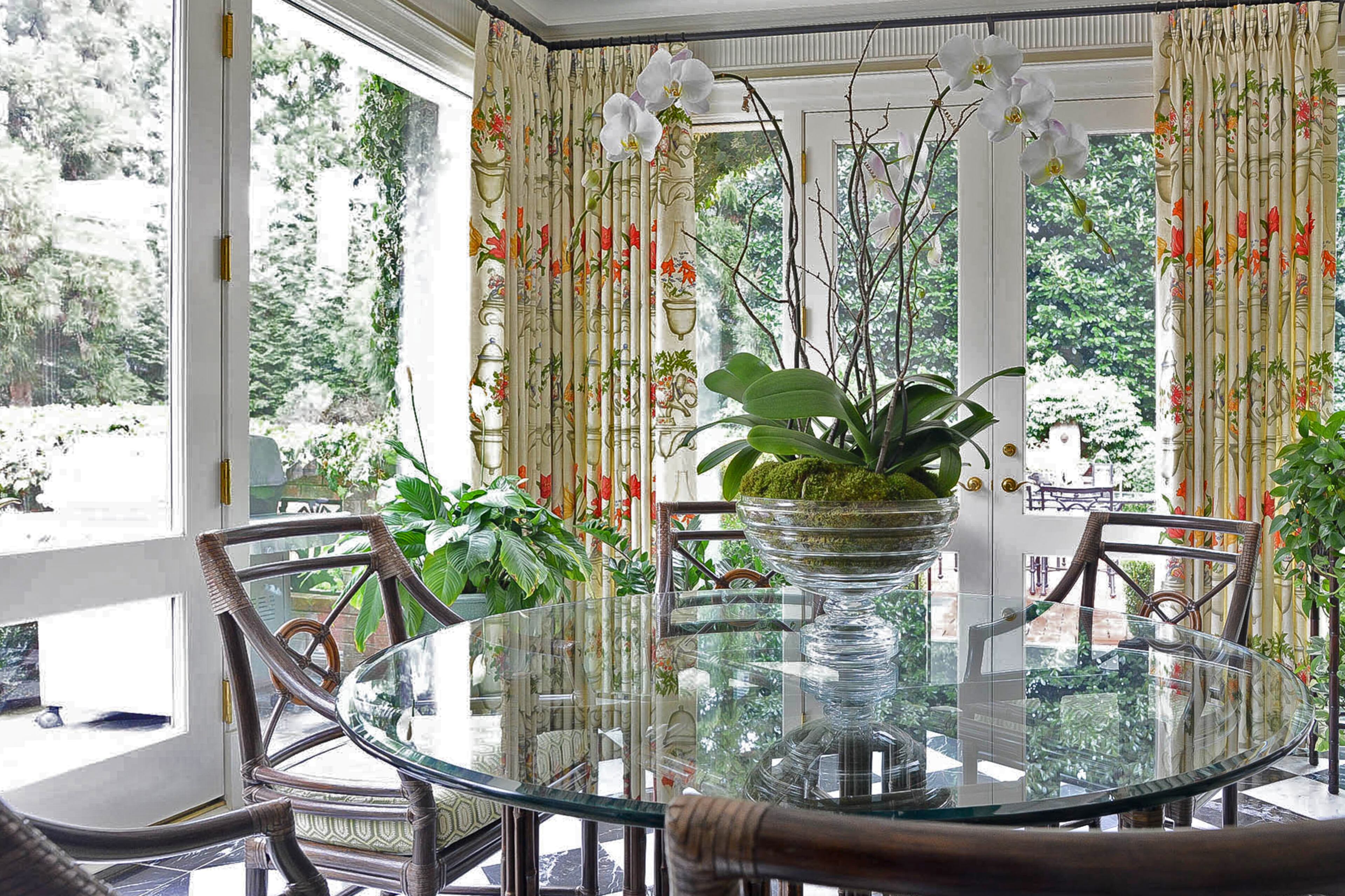 In lieu of a formal dining room, John Banks has round glass-topped tables in his garden room and the living room. Here, they overlook the pool and terrace through plate-glass windows.