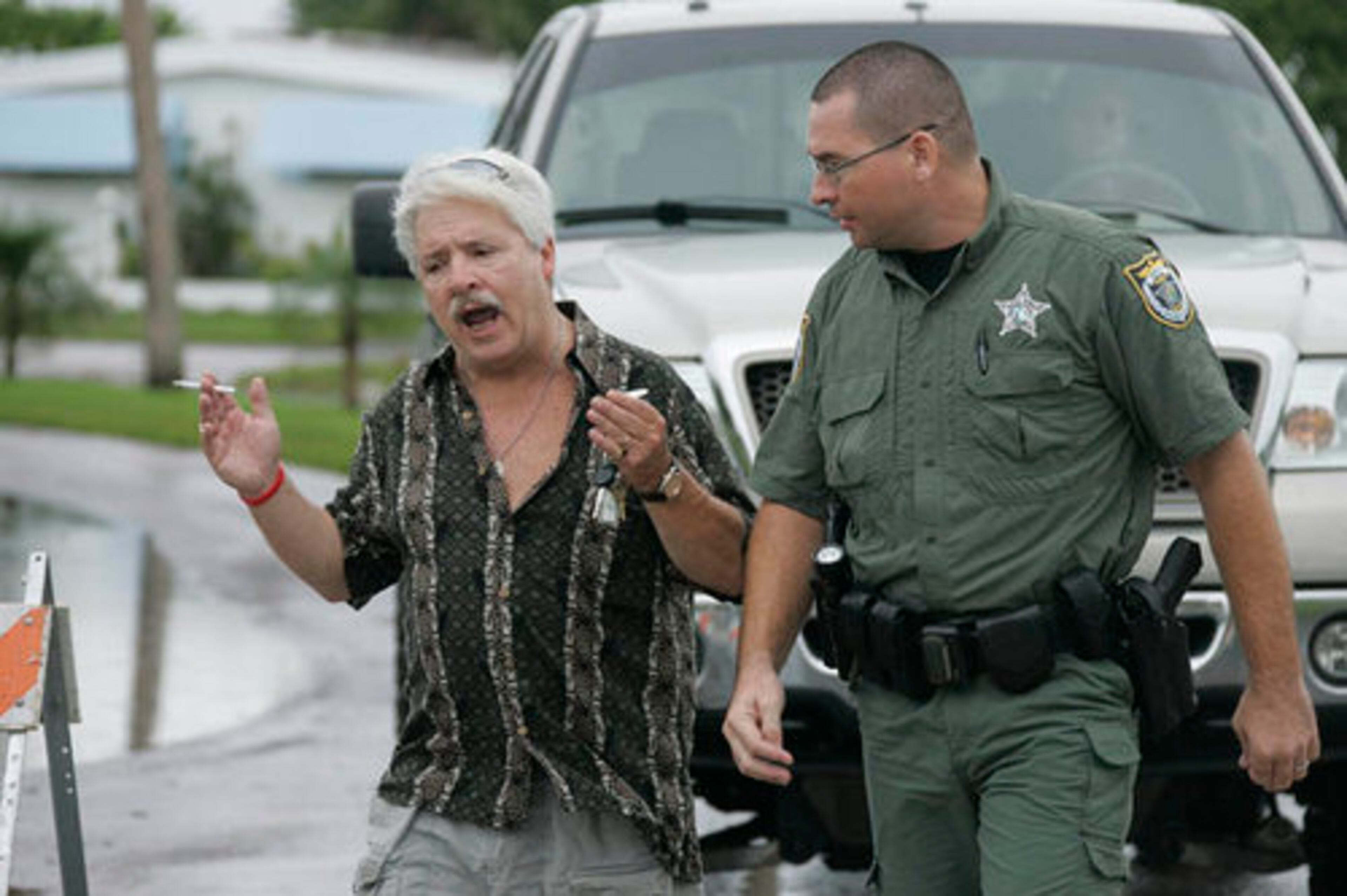 Brevard Deputy Sheriff Tygh Freeman escorts a resident of the Lamplighter Village in Melbourne, Fla. back to his car after refusing him permission to return to his home because the area was flooded.