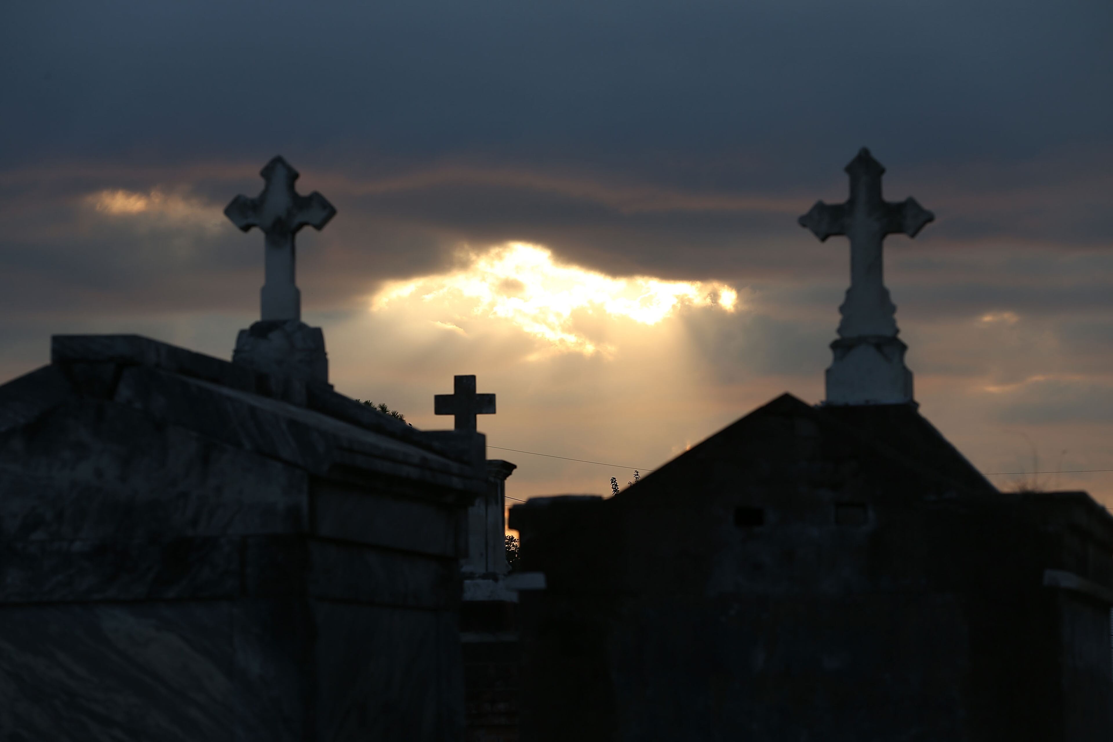 NEW ORLEANS, LA - AUGUST 29: The sun breaks through the clouds over a cemetery as the region remembers Hurricane Katrina on the 10th anniversary of it making landfall on August 29, 2015 in New Orleans, Louisiana. Hurricane Katrina, killed at least 1836 and is considered the costliest natural disaster in U.S. history. (Photo by Joe Raedle/Getty Images)