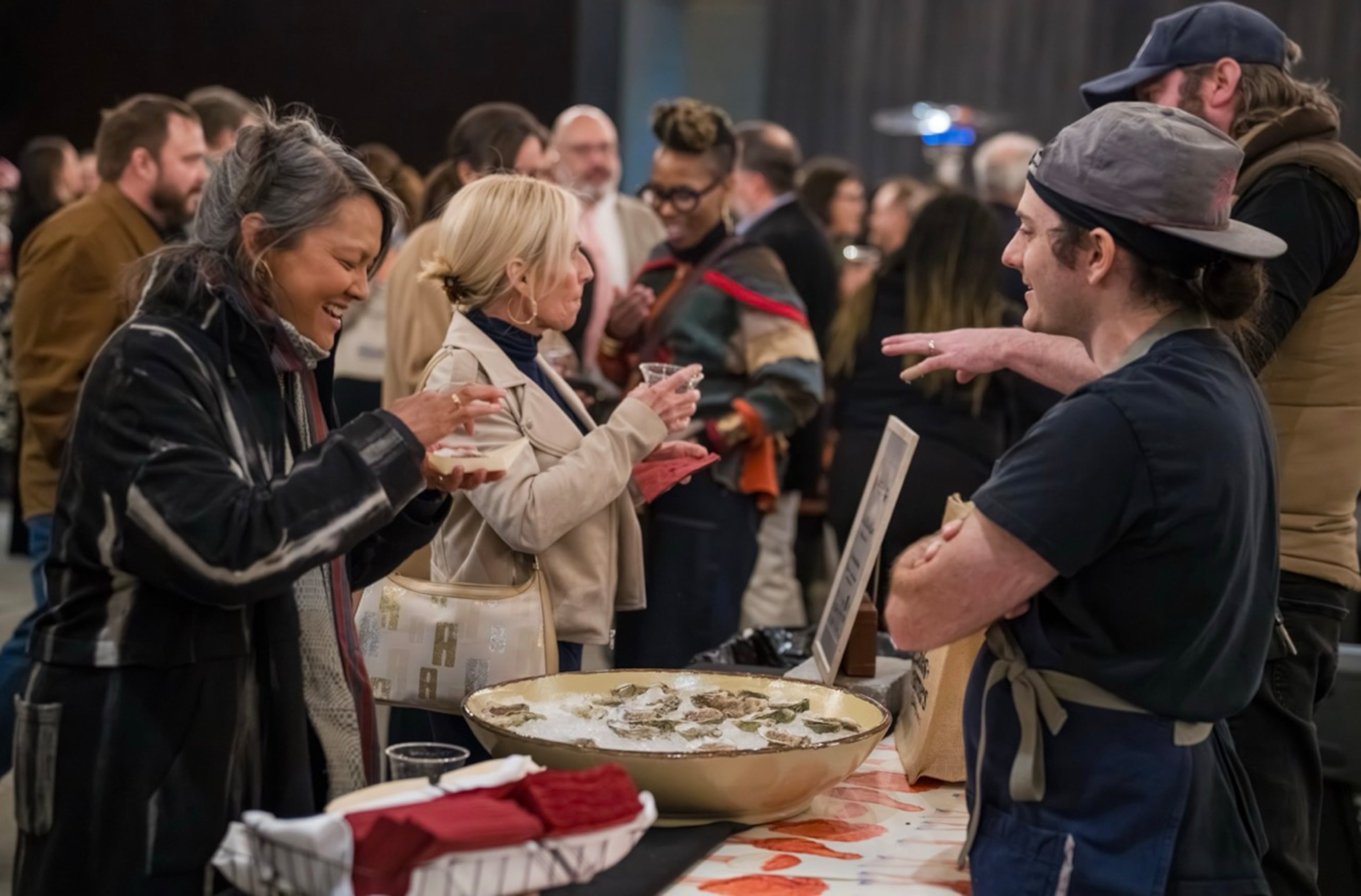 An attendee at the inaugural Chefs + Farmers in 2025 samples oysters prepared by Brochu's Family Tradition, one of the restaurants that will return for the event on March 5 at Ships of the Sea Maritime Museum in Savannah. (SV Images, LLC/Courtesy of FARM Hospitality Group)