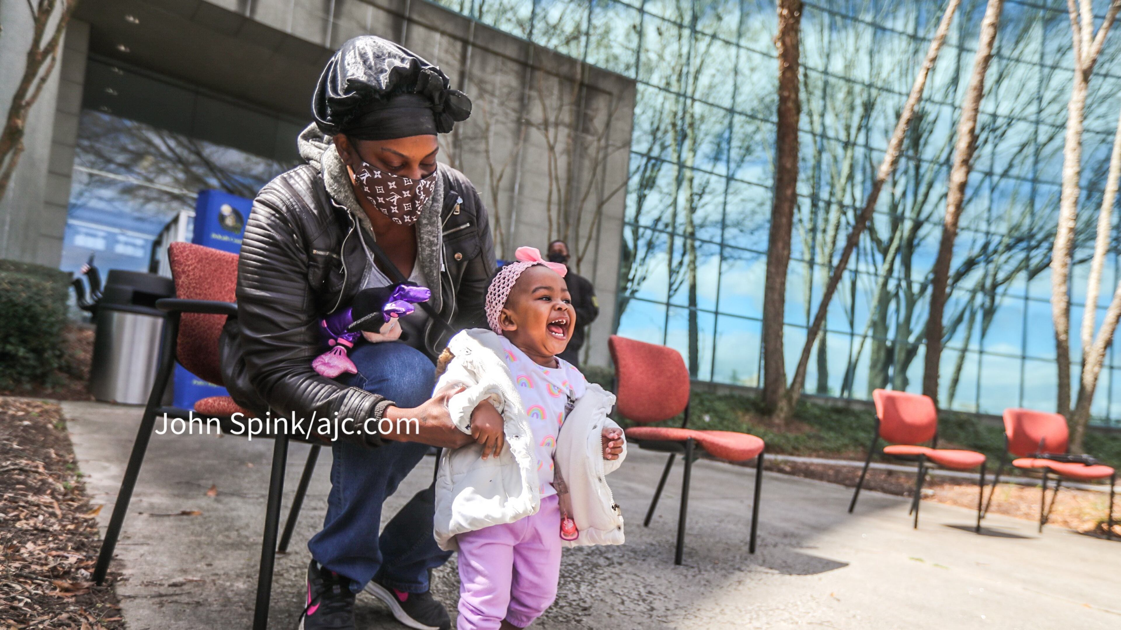 Elizabeth Grisby holds a beaming Royalty Grisby, 1, outside DeKalb County police headquarters Friday before providing an update on the child's condition following her harrowing abduction the day before.