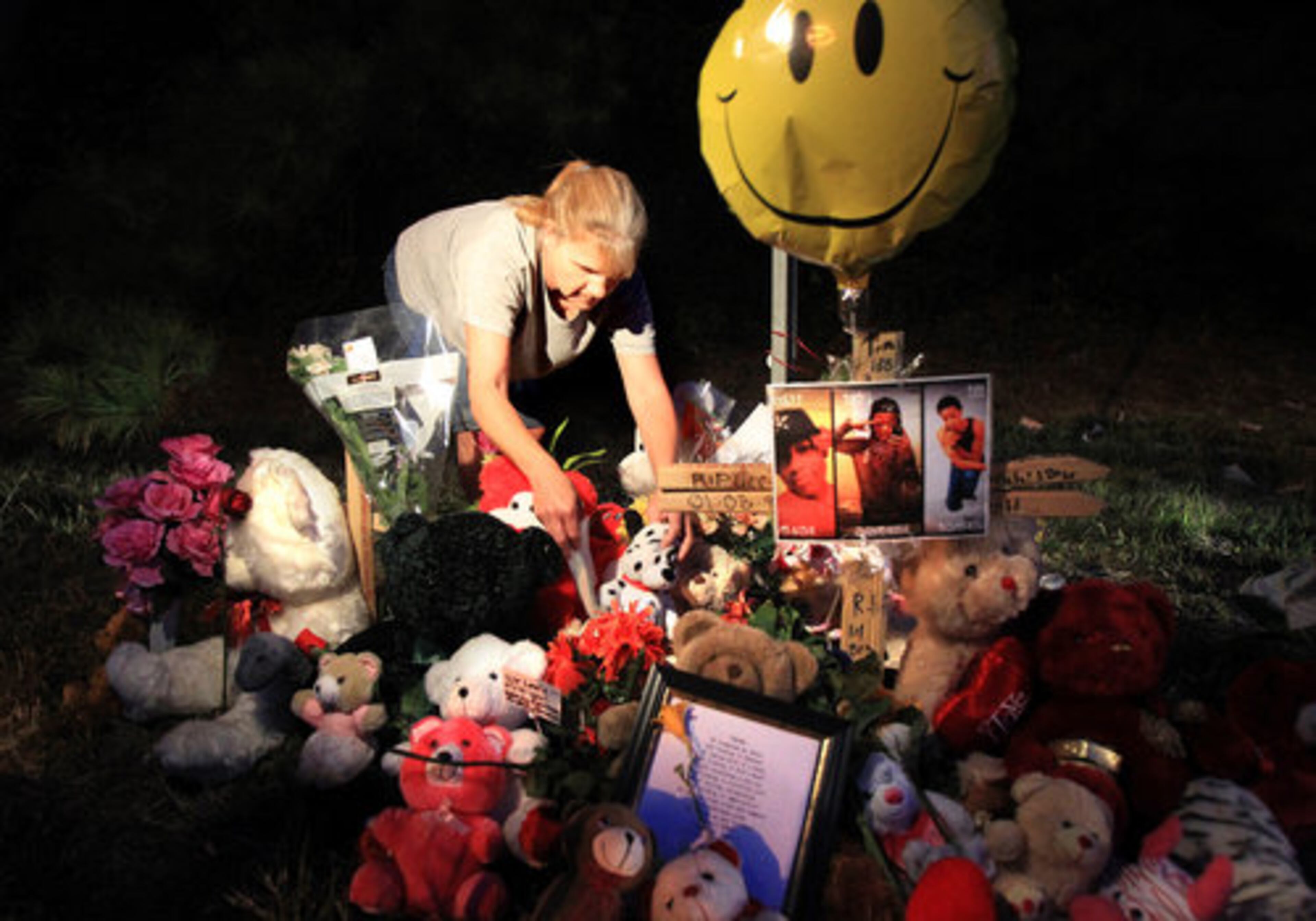 Family friend Hope Blakenship of Stockbridge tends the roadside memorial.
