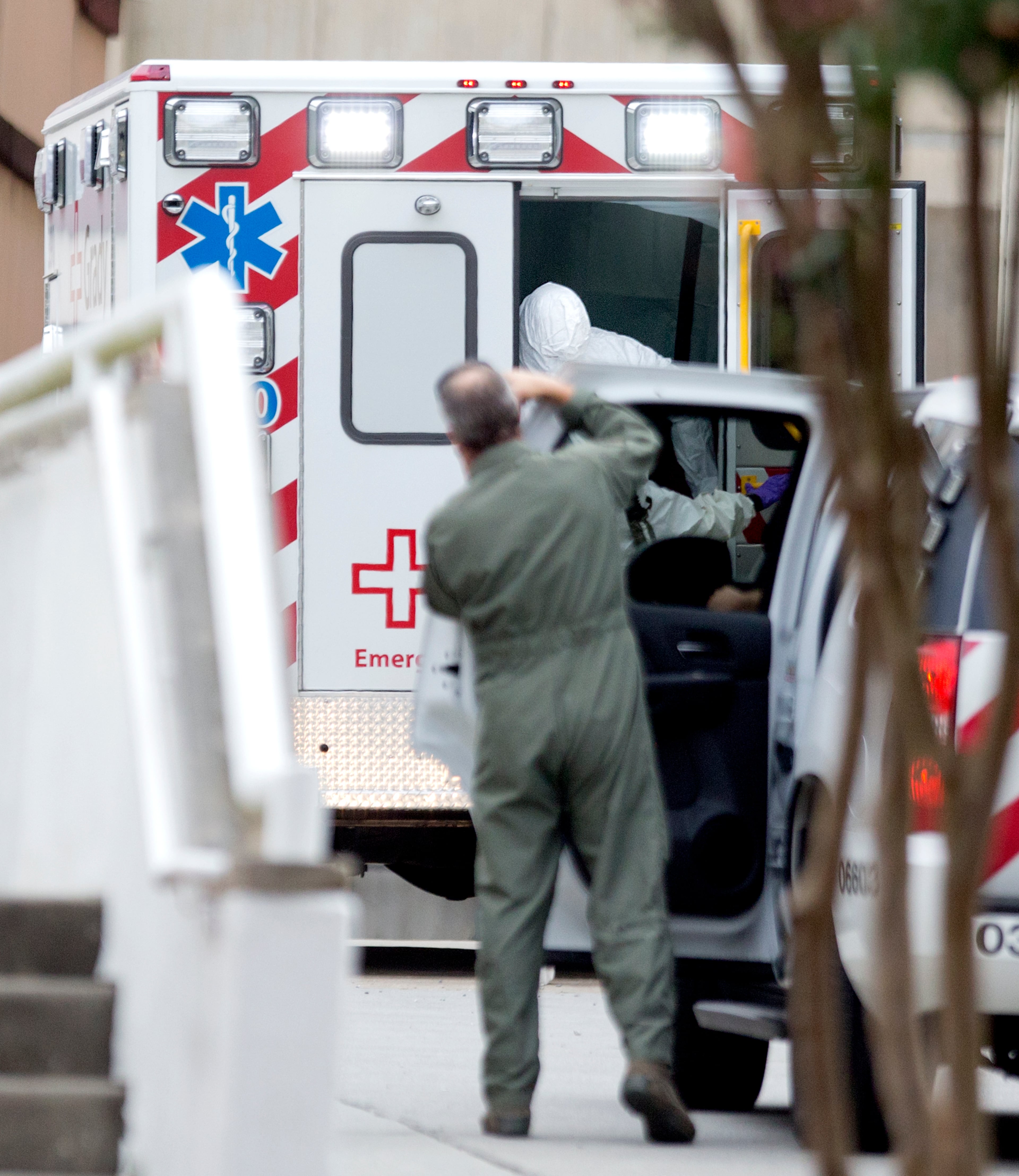 A person wearing a haz-mat suit steps out of an ambulance as an ebola patient arrives for treatment, Tuesday, Sept. 9, 2014, in Atlanta. The fourth American aid worker sickened with the Ebola virus arrived Tuesday morning for treatment at Emory University Hospital, where two others have been successfully treated. (AP Photo/David Goldman)