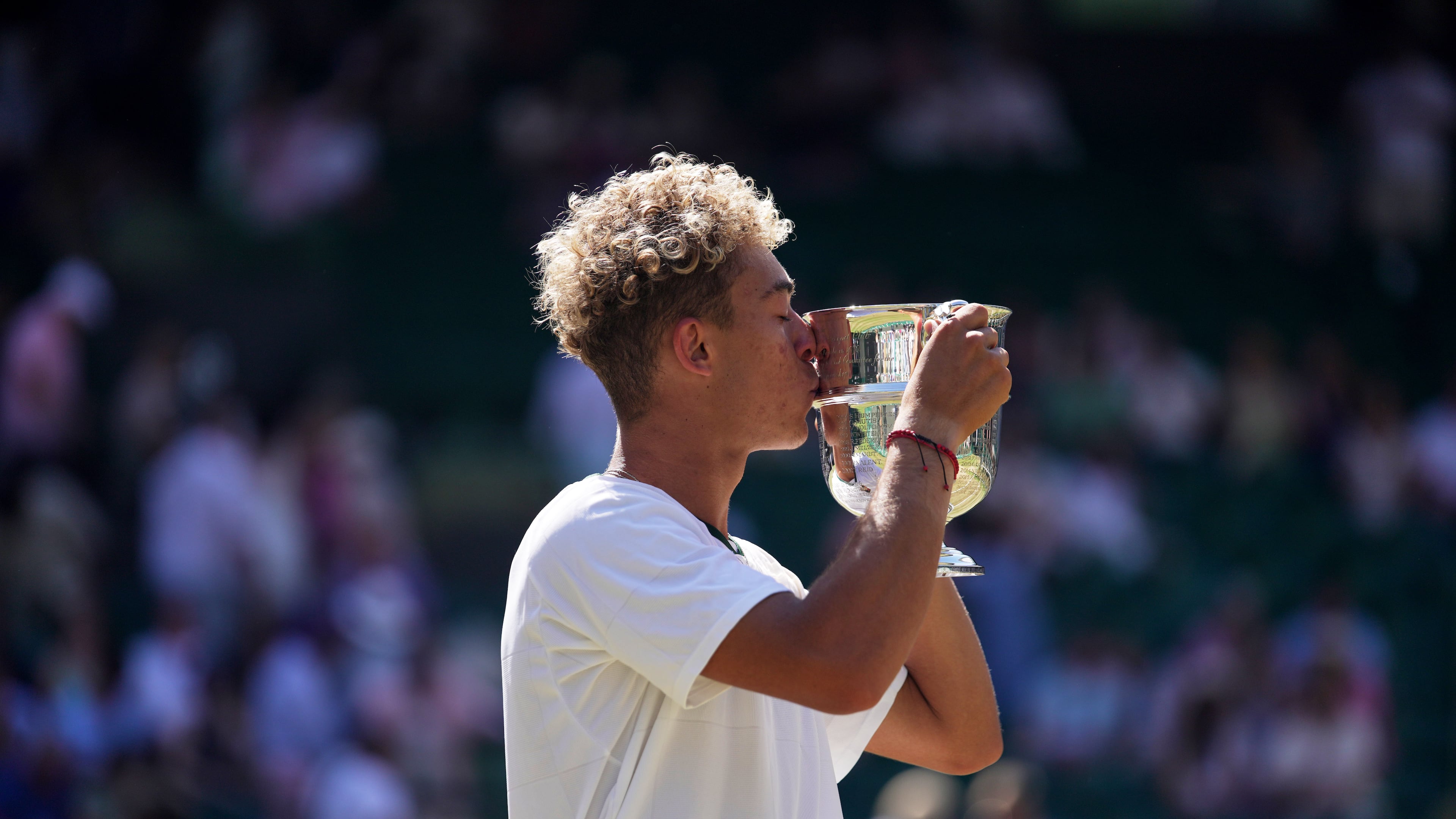 Jordan Lee of the United States kisses the trophy after winning against Cruz Hewitt of Australia in the boy's singles final at the Wimbledon Tennis Championships in London, Sunday, July 12, 2026. (AP Photo/Brian Inganga)