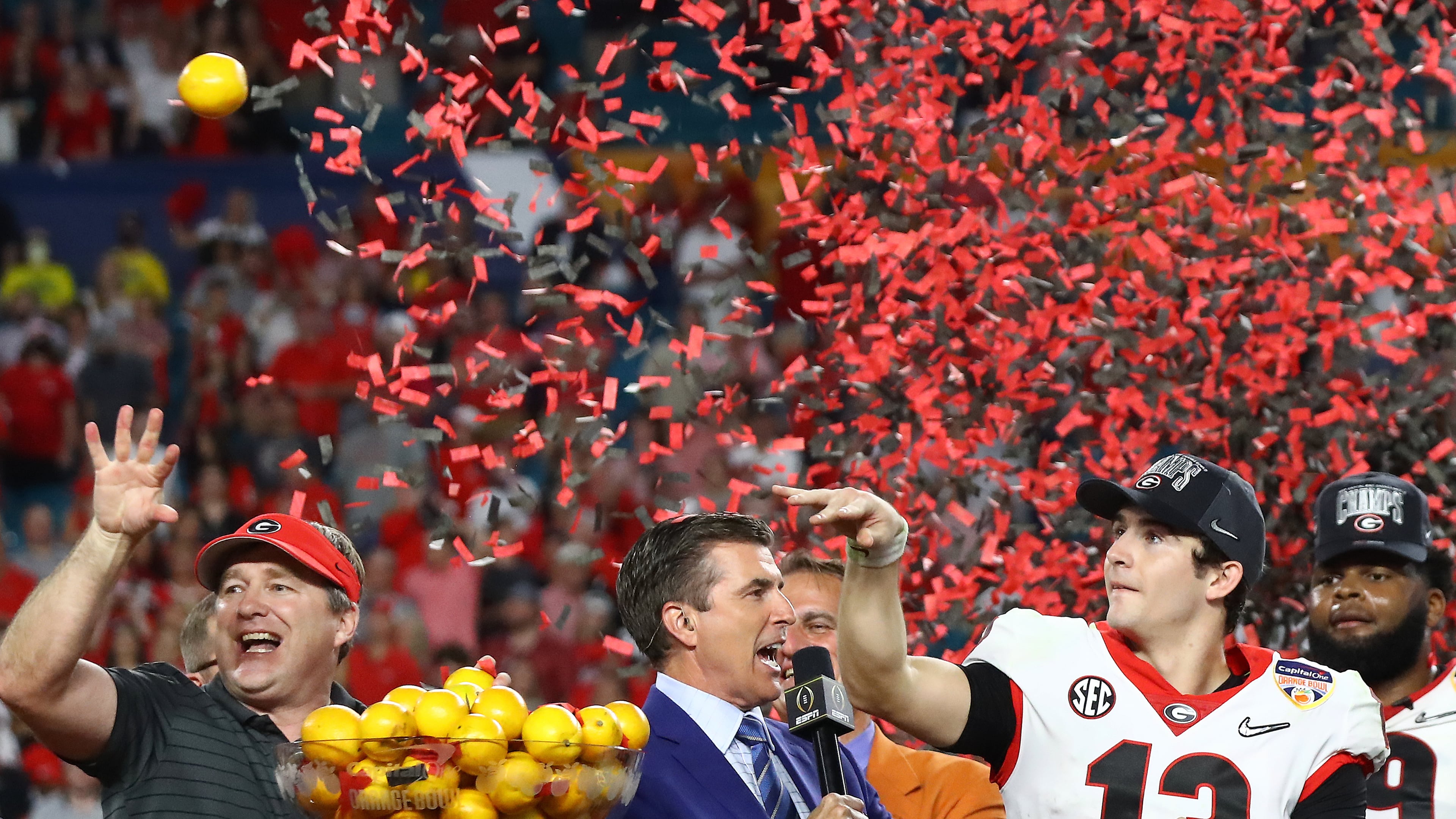 12/31/21 - Miami Gardens - Georgia head coach Kirby Smart and quarterback Stetson Bennett toss oranges from the trophy stage after beating Michigan 34-11 to win the Orange Bowl at Hard Rock Stadium on Friday, Dec 31, 2021, in Miami Gardens. Curtis Compton / Curtis.Compton@ajc.com