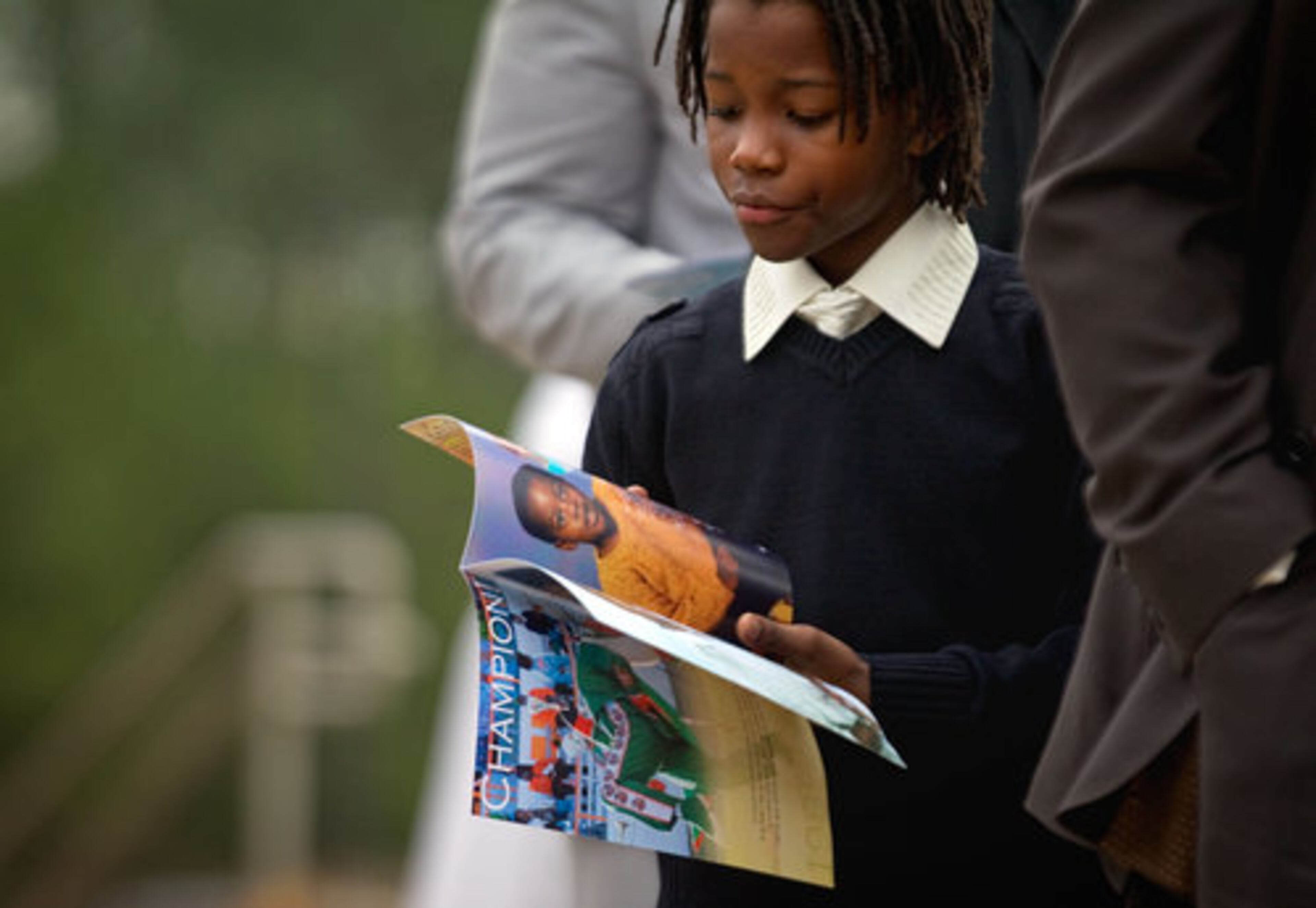 A family member looks at the program before the start of the funeral service for Champion.