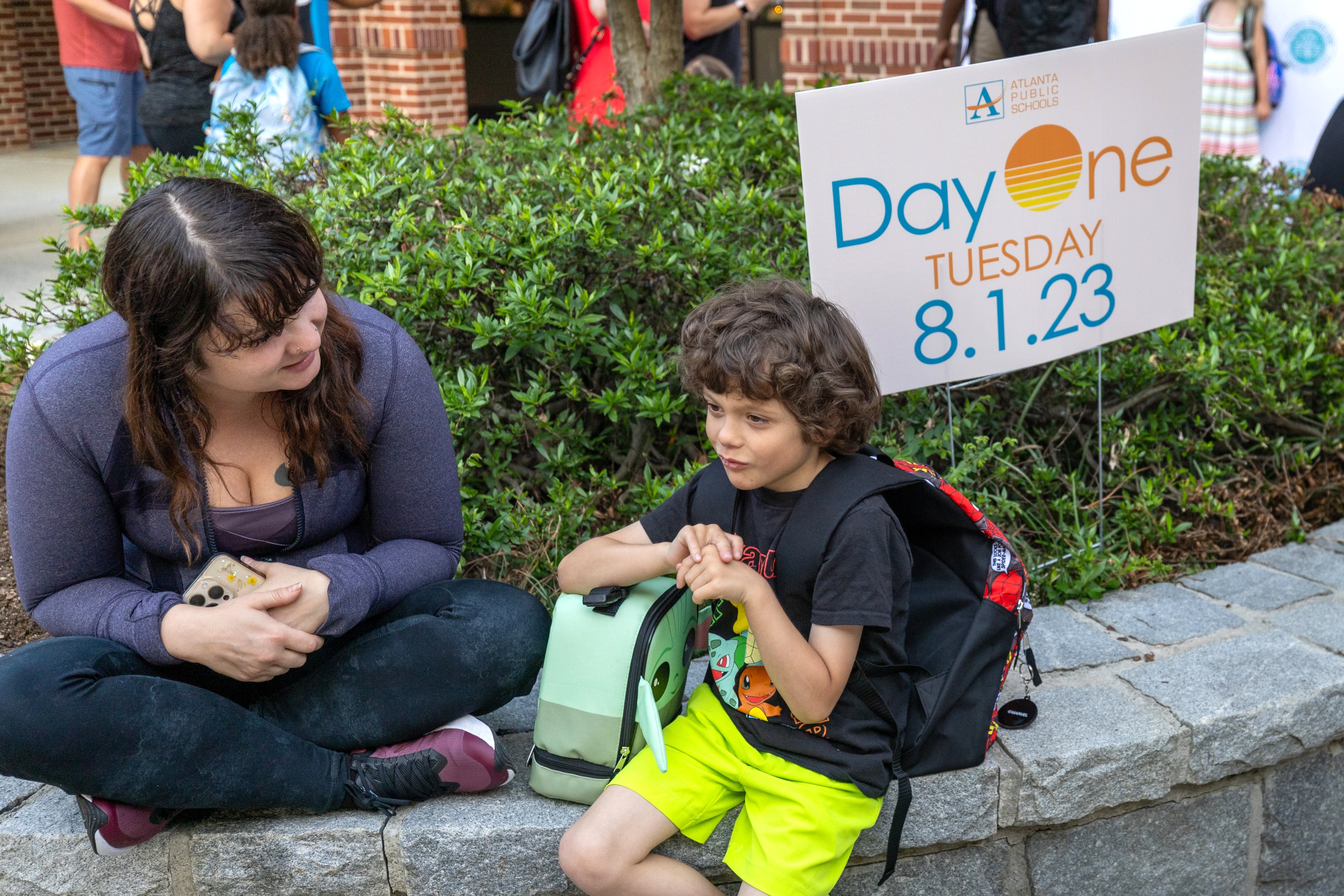 Ashley Simpson and her son Harrison, 7, sit outside Virginia-Highland Elementary, waiting for the first day of school to start Tuesday, August 1, 2023. (Steve Schaefer/steve.schaefer@ajc.com)